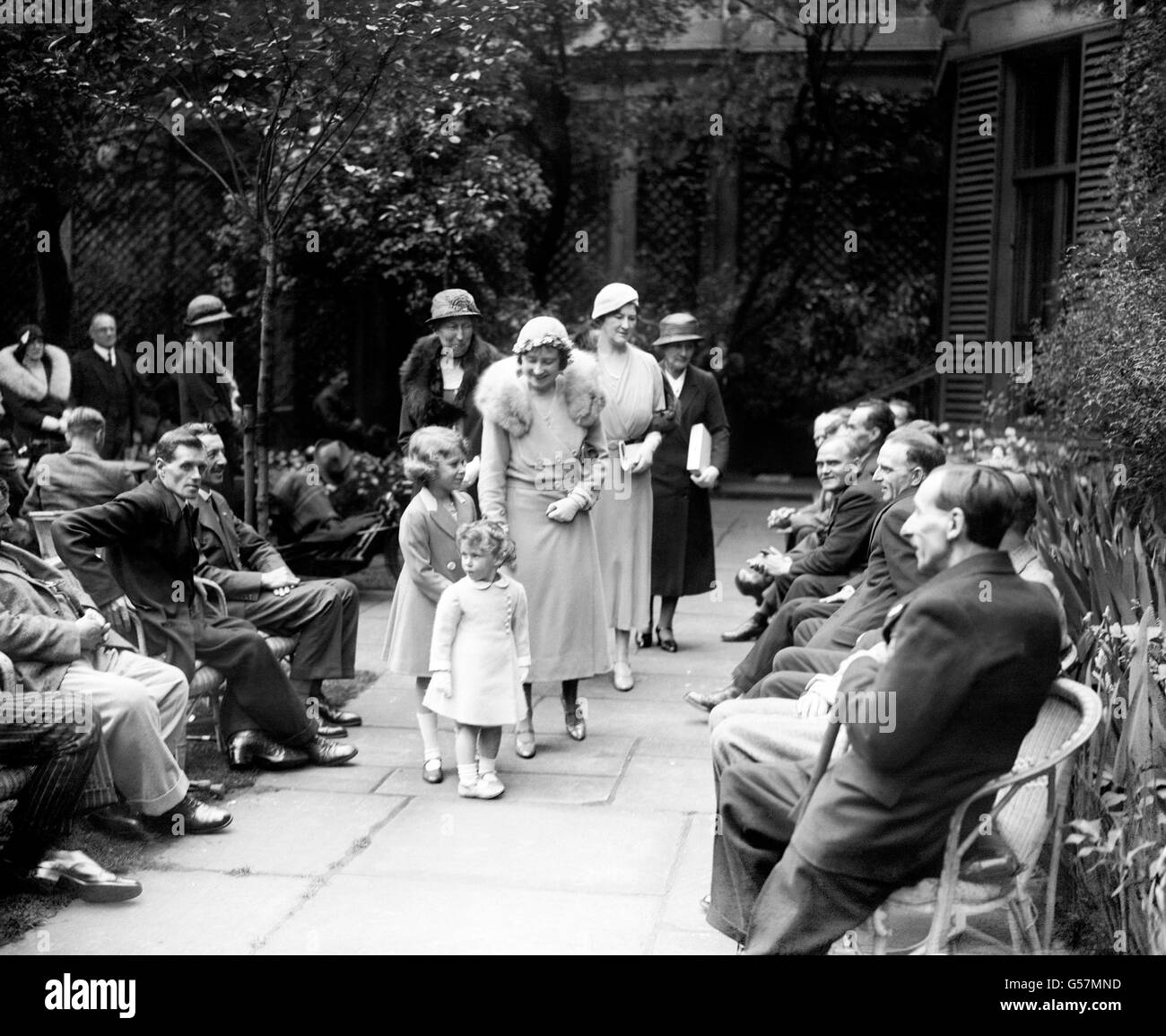 The Duchess of York (centre) and her two small daughters Princess Elizabeth (left) and her sister Princess Margaret (front) at a Disabled ex-soldiers sale of work at 35 Lowndes Square in London. Stock Photo