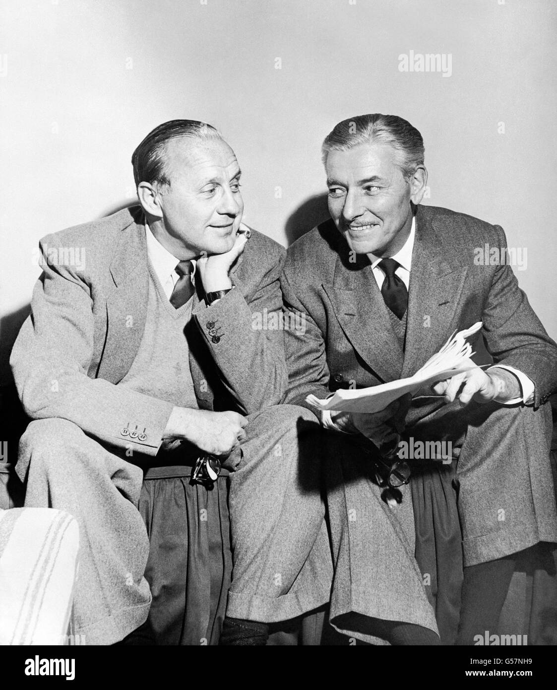 Comedian Jack Benny, left, and British-born actor Ronald Coleman, conferring amiably over a script in Hollywood, USA. Stock Photo