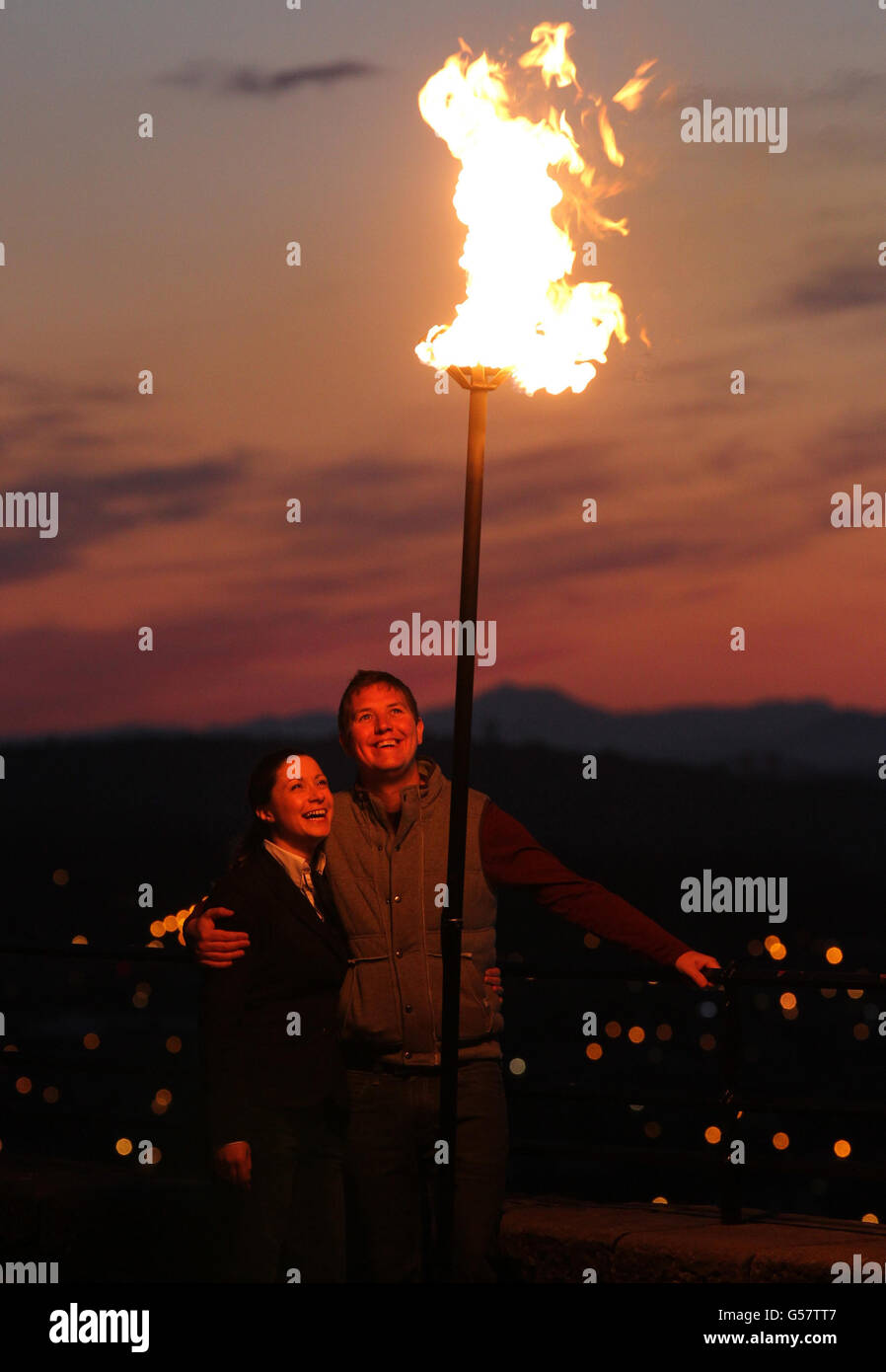 Laura Hammond with fiancee Greig Mitchell from the Royal Institution of Chartered Surveyors watch the Diamond Jubilee beacon at Edinburgh Castle beside Mons Meg Cannon. Stock Photo