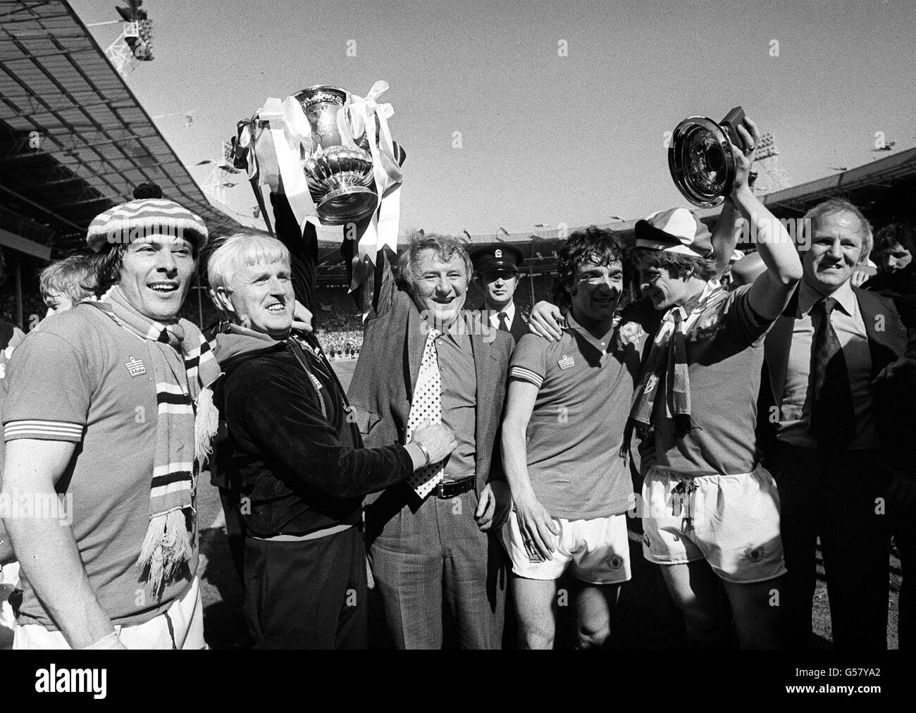 4TH JULY: On this day in 1977 Manchester United sacked their manager Tommy Docherty, seen here winning the FA Cup in May of the same year. Revelry from Manchester United manager Tommy Doherty at Wembley Stadium with members of his team and training staff after their 2-1 win over Liverpool in the final of the FA Cup. * From left are: Stuart Pearson, Tommy Cavanagh (trainer), Tommy Docherty, Lou Macari, Gordon Hill and Frank Blunstone (a member of training staff). Stock Photo