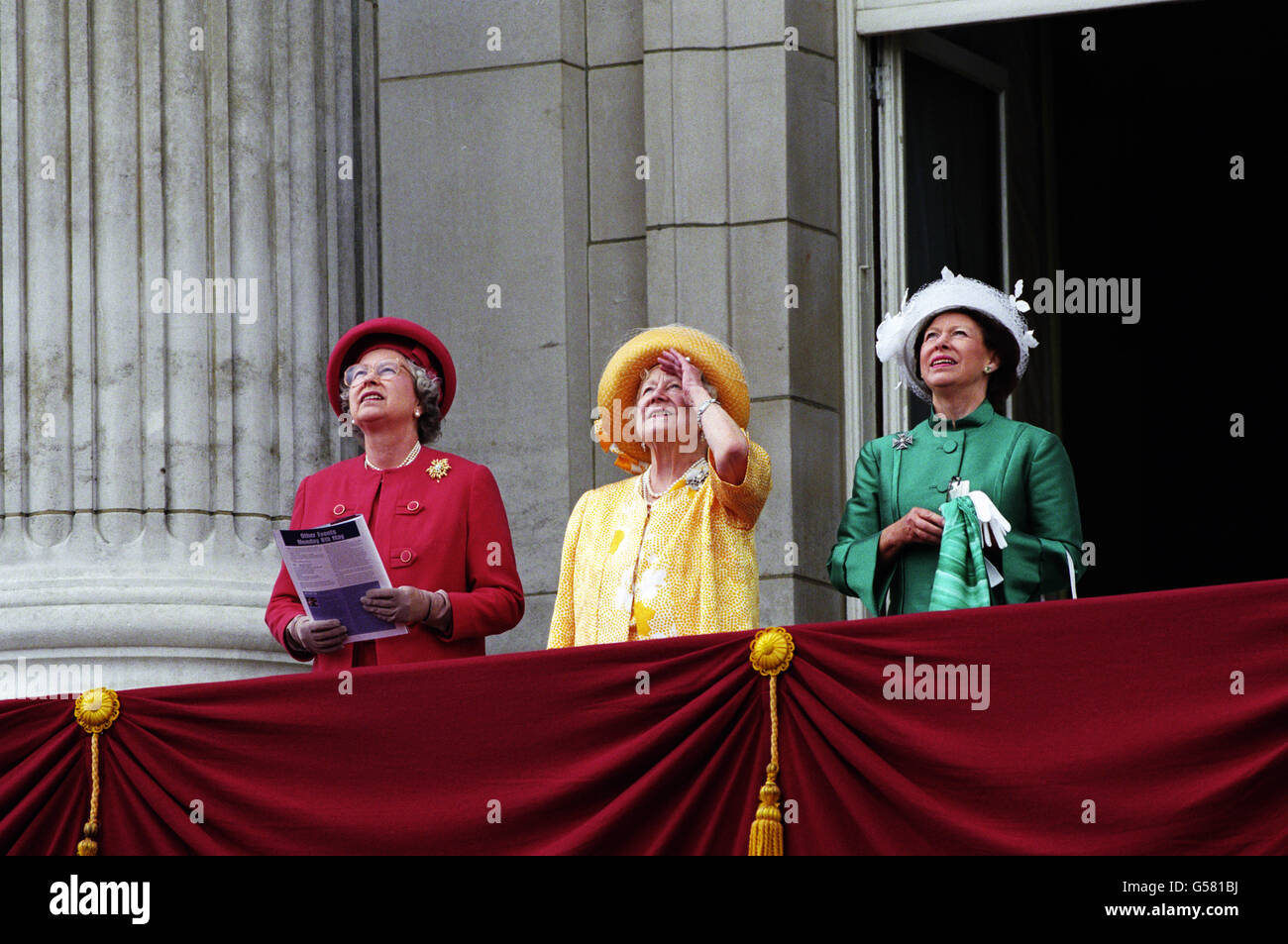 VE DAY 1995: (l-r) The Queen, The Queen Mother and Princess Margaret watch a procession of vintage planes fly over Buckingham Palace. Stock Photo