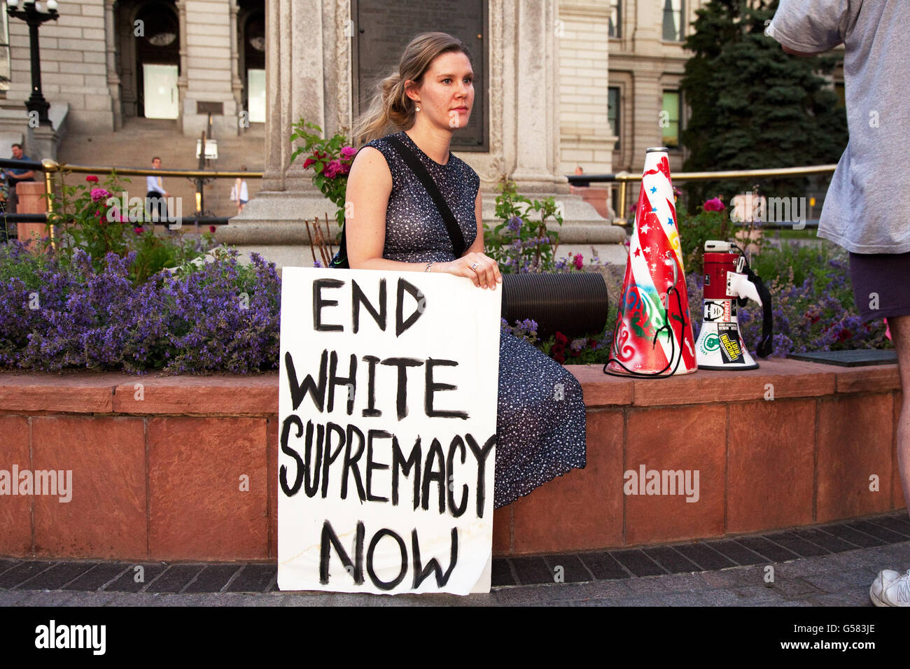 Denver, Colorado, USA. 23rd June 2015. Demonstrator with sign waits for beginning of rally to protest state-sponsored racism, such as the flying of the Confederate flag at the South Carolina State Capitol and the shooting of unarmed black men by white police officers. © Stuart Sipkin/Alamy Live News. Stock Photo