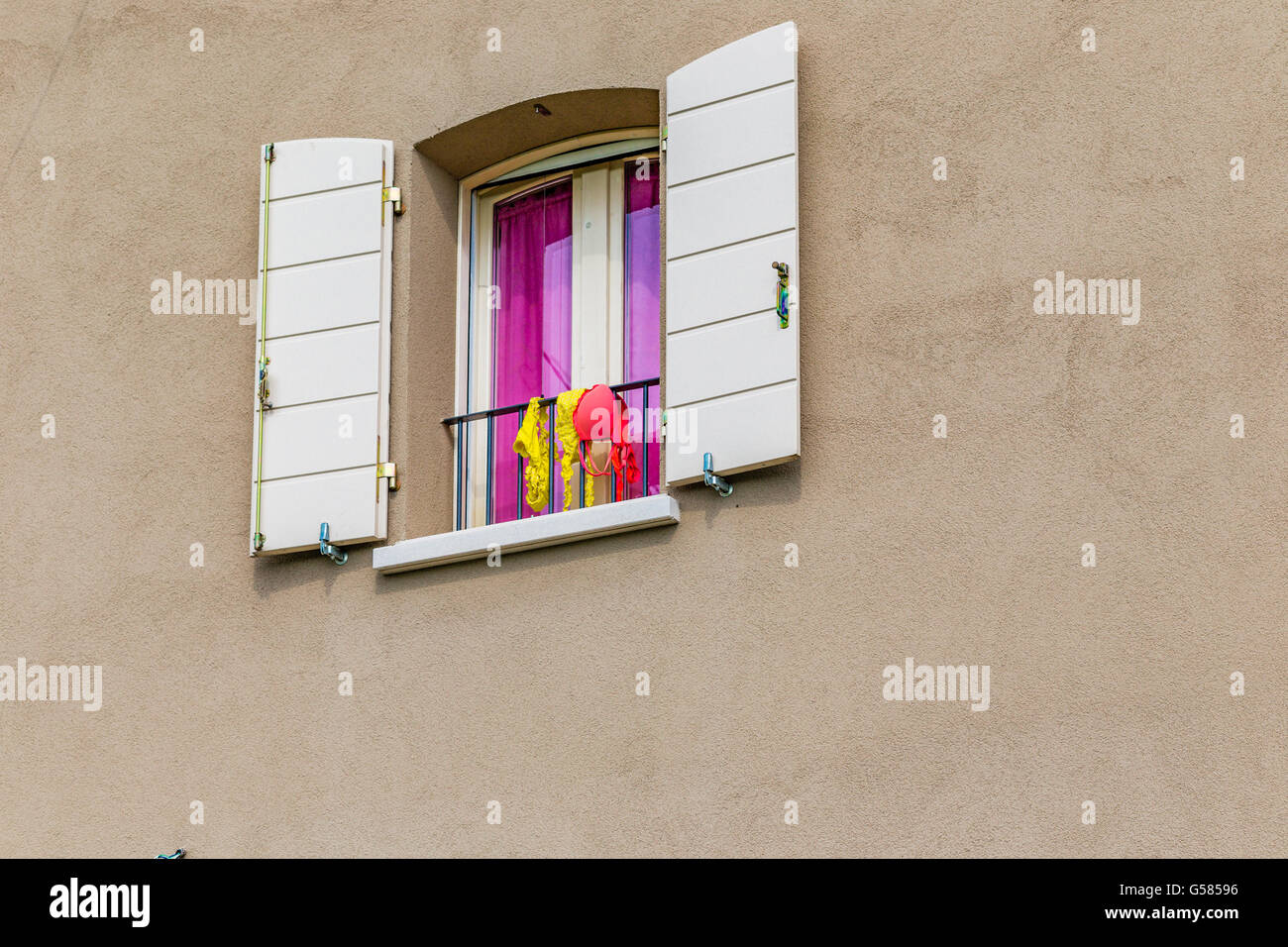 window with women swimsuits hung out to dry Stock Photo