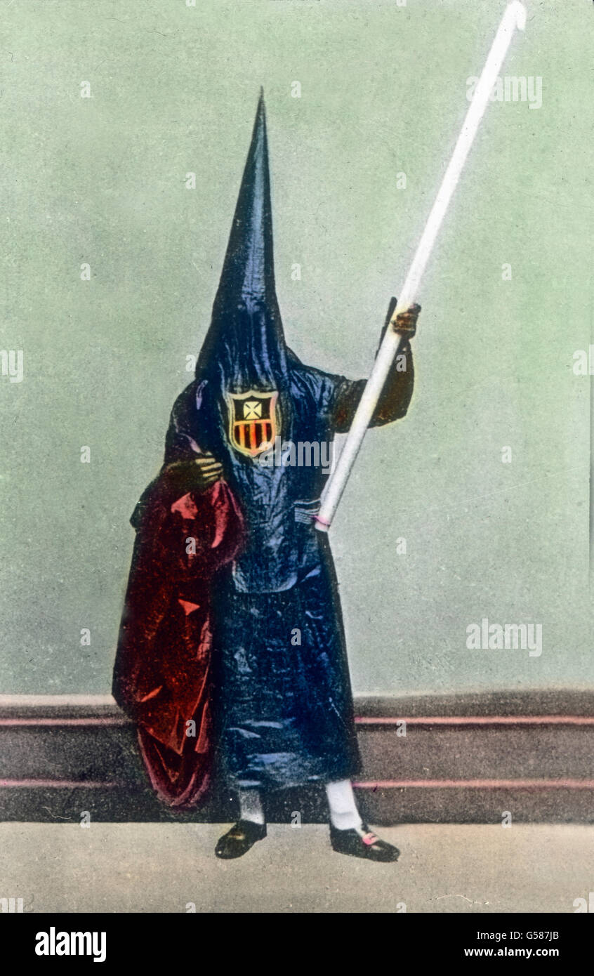 Diese merkwürdige Erscheinung stellt einen Mann dar, der ein Kirchenfest ankündigt, wie sie  namentlich in Sevilla  mit großem Pomp in der Öffentlichkeit begangen werden. Ursprünglich war das eine Tracht, wie sie Männer, meist Mönche, trugen, die Pestkranke beförderten oder Pesttote beerdigten. Durch die Tracht sollten Menschen gewarnt werden. Das war im Mittelalter. Heute soll diese Tracht daran erinnern, daß man selbst bei kirchlichen Freudenfesten immer die Losung memento mori (Gedenke des Todes) beherzigen sollte. Europe, Spain, Sevilla, Andalusien, Seville, Andalusia,  travel, 1930s, 1920 Stock Photo