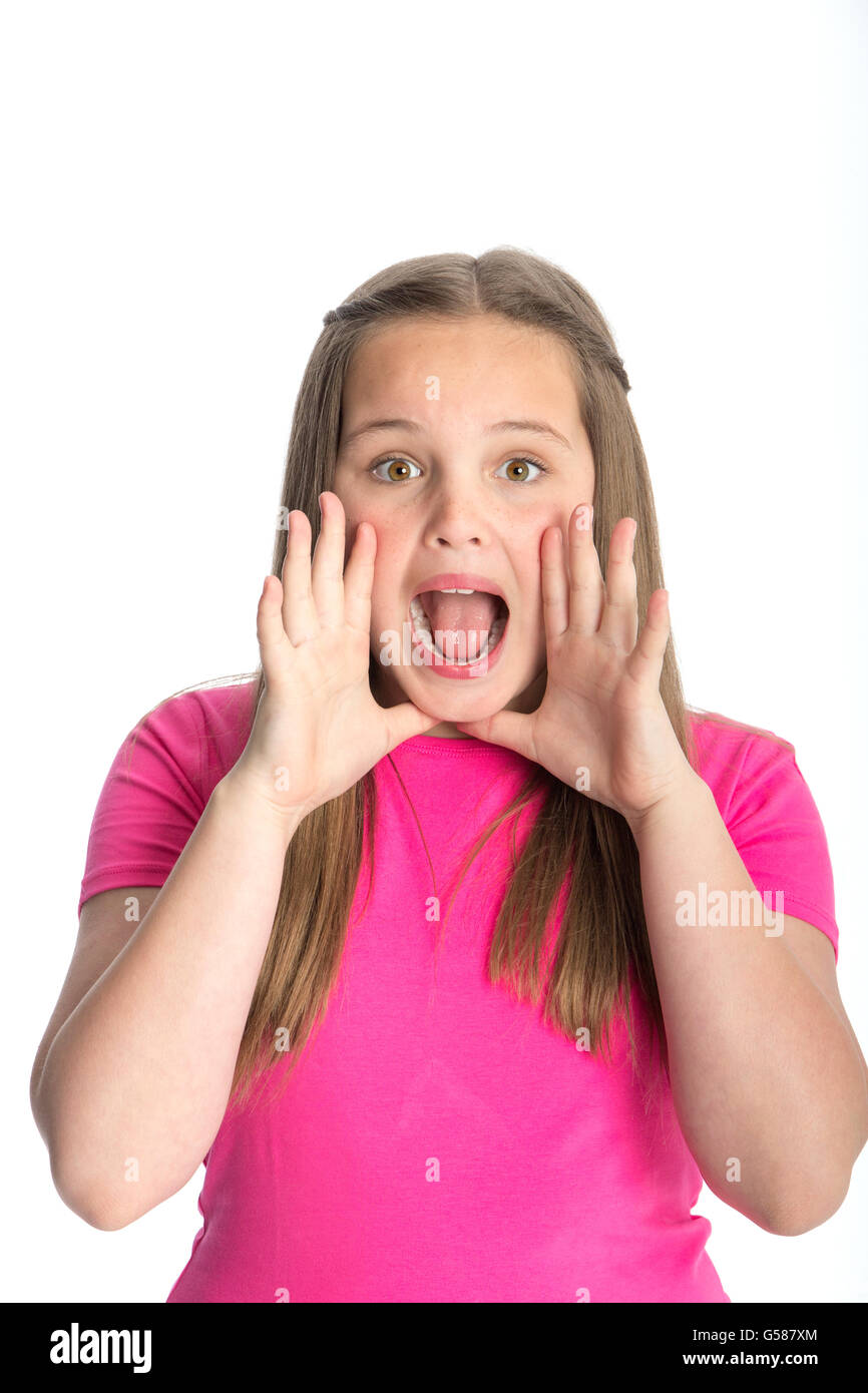 Young girl gesturing a shout at the camera. She is standing against a white background. Stock Photo