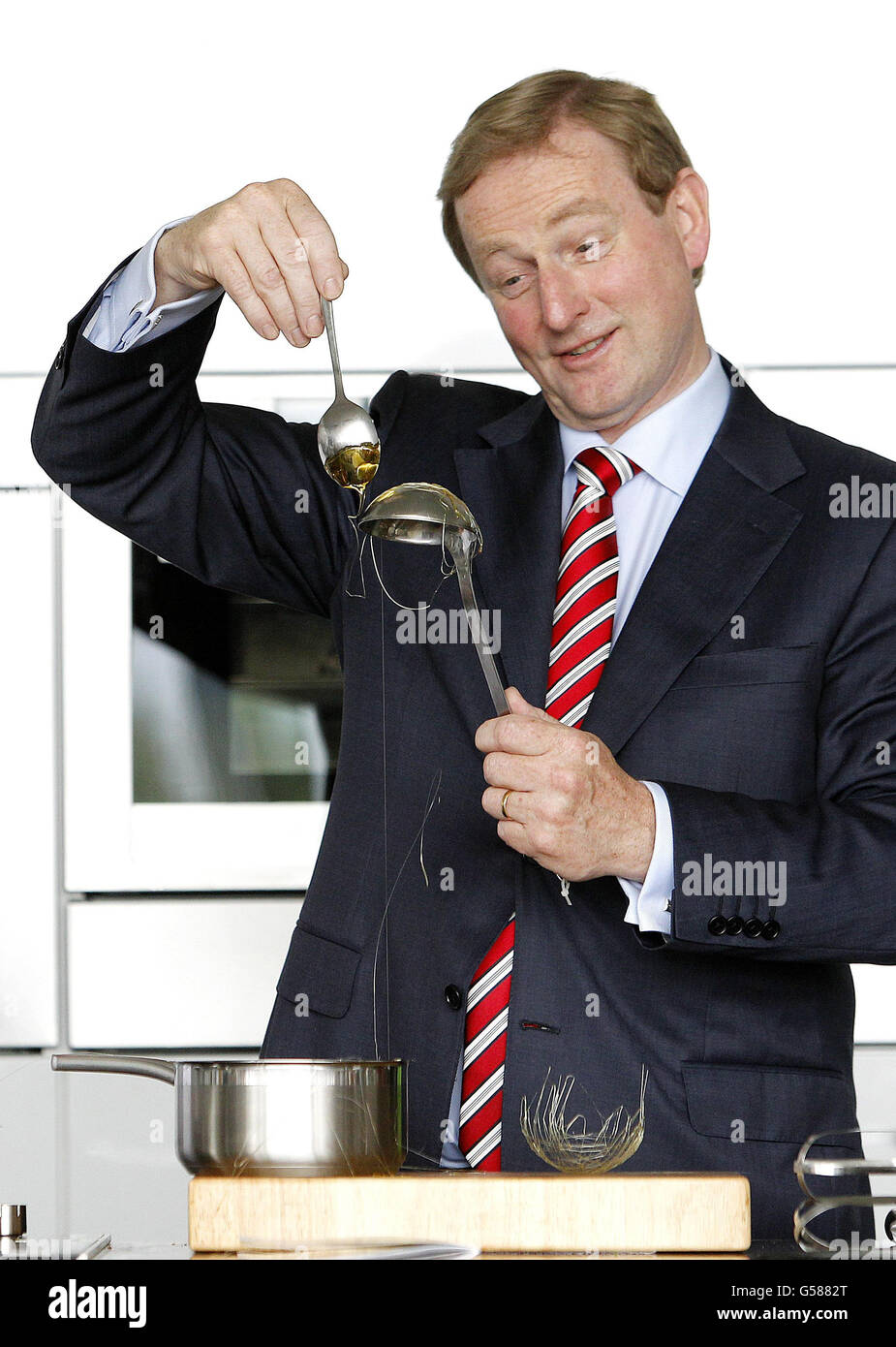 Taoiseach Enda Kenny drips melted sugar onto a spoon to make a sugar basket on the Bord Bia stand at the Bord Bia Bloom festival in the Phoenix Park, Dublin as the counting in the Fiscal Stability Referendum continues. Stock Photo