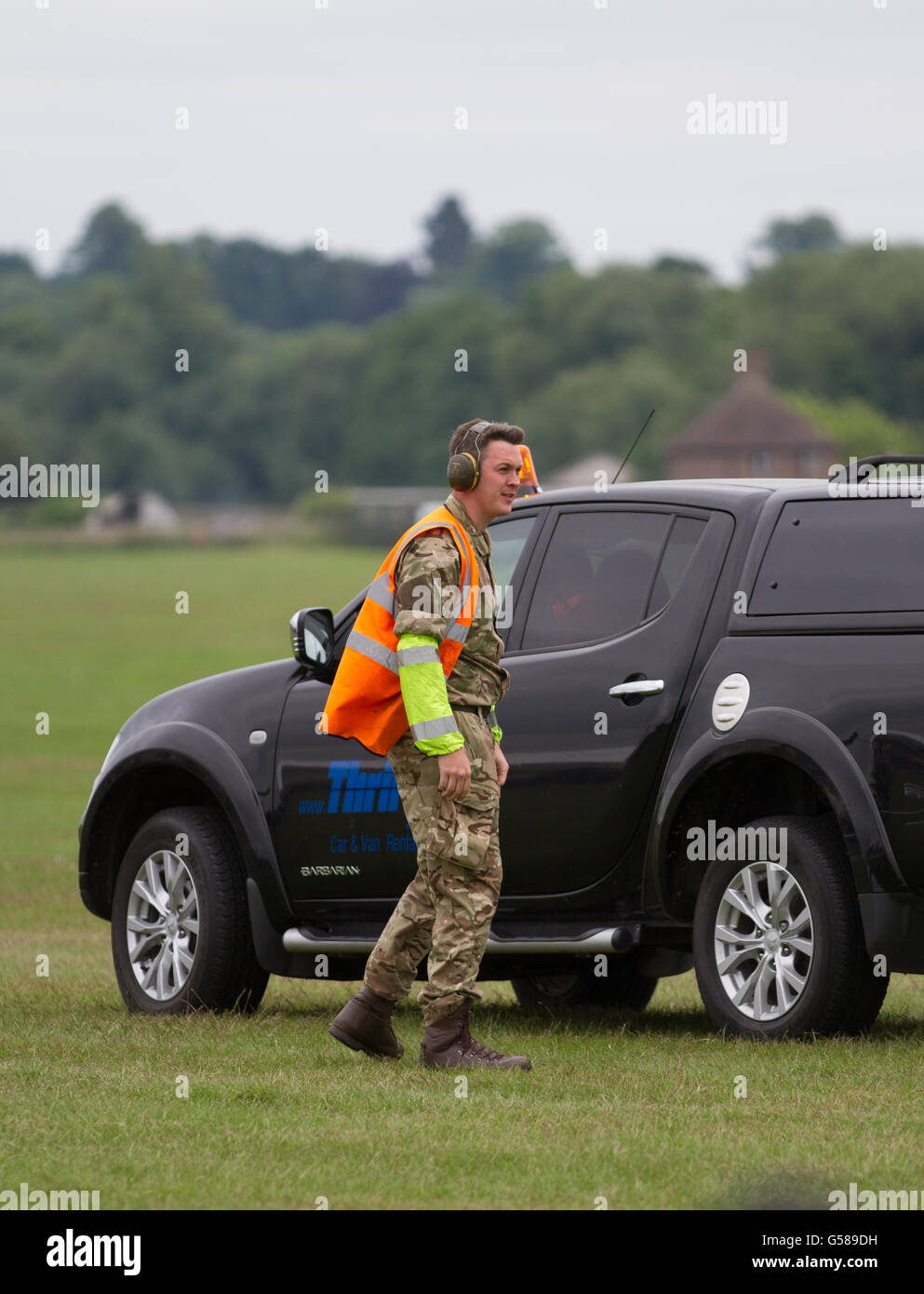 Does he want to be seen - A contrast of Hi vis and camouflage at Cosford Air Show as an MOD photographer catches a lift. Stock Photo
