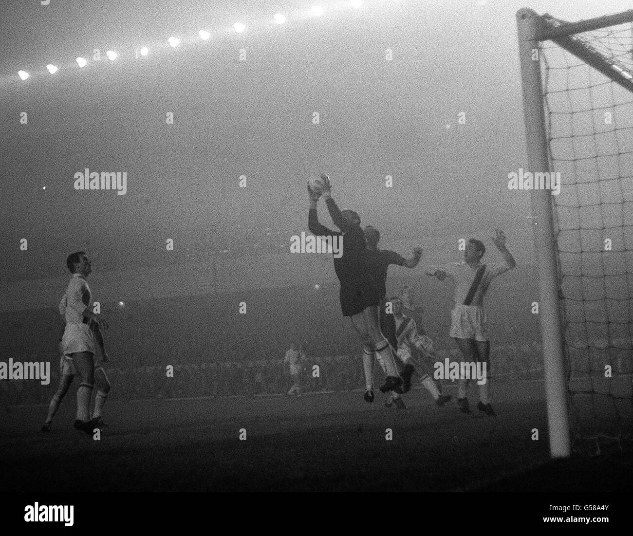 Italian club Napoli's goalkeeper Pacifico Cuman (centre) jumps to save a shot from Bangor City, during their European Cup Winners' Cup first round replay football match, played in fog at Highbury stadium, north London. * Jumping up behind Cuman is Bangor's Jimmy McAllister, and right is Napoli's Giovanni Molino. Stock Photo