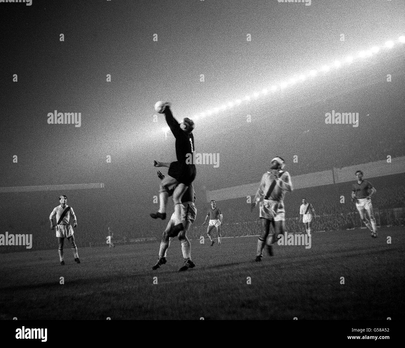 Italian club Napoli's goalkeeper Pacifico Cuman (centre) jumps high to clear a shot from Bangor City, despite the challenge from Bangor's Brown (behind), during their European Cup Winners' Cup first round replay football match at Highbury, London. * Jumping up behind Cuman is Bangor City's Jimmy McAllister, and right is Napoli's Giovanni Molino. Stock Photo
