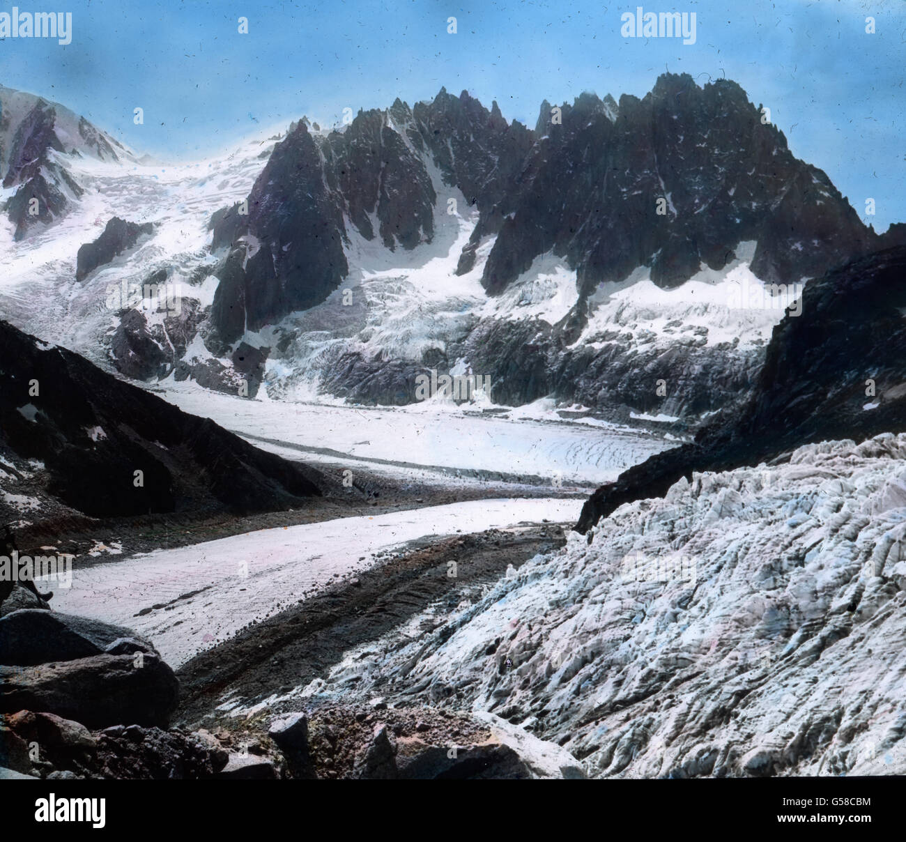 Wir wählen dazu nicht dieselbe Route wie vorher, sondern überqueren den Talefre-Gletscher nach Südosten hin und gelangen an der linken Seite des Gletschersturzes in die Felsen. Dort bietet sich uns nicht bloß der Blick auf die in den eigentümlichsten Formen aufragenden Eismassen (in dieser Ansicht zur Rechten), sondern auch auf die ganze Kette der Aiguilles, die sich von der Vallee Blanche nach der Mer de Glace zu hinziehen, von der Aiguille du Midi angefangen bis denen von Charmoz; dieses Bild ist gleichzeitig eine Ergänzung des vorigen nach Nordosten hin. Mont Blanc, mountain chain, Pierre a Stock Photo