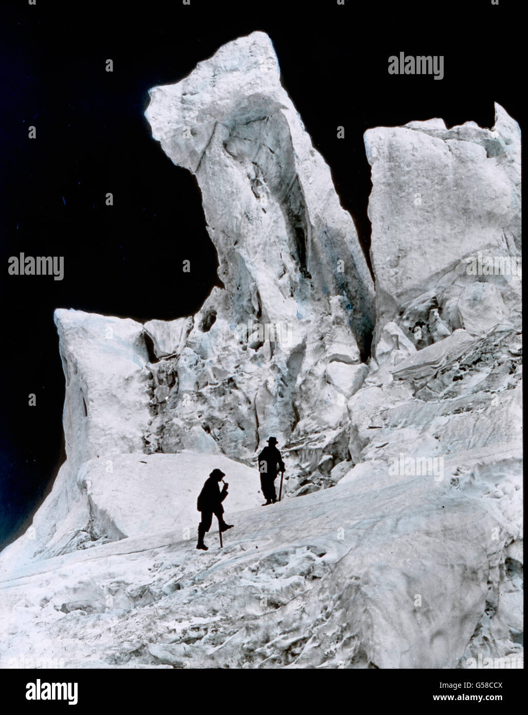 Zu beiden Seiten des eben erwähnten Eistales steigen die Eismassen in den abenteuerlichsten Formen empor. Wir betrachten mit Staunen die phantastischen Türme und Nadeln, deren Oberfläche von den Sonnenstrahlen zernagt und zerfressen ist. Tiefblau erscheinen uns die Hohlräume, während die Außenseite das Licht strahlend zurückwirft und ein unheimliches Glitzern und Flimmern uns blendet. Mont Blanc, mountain chain, Ice storm of glacier Bossons, history, historical, Carl Simon, hand coloured glass slide Stock Photo