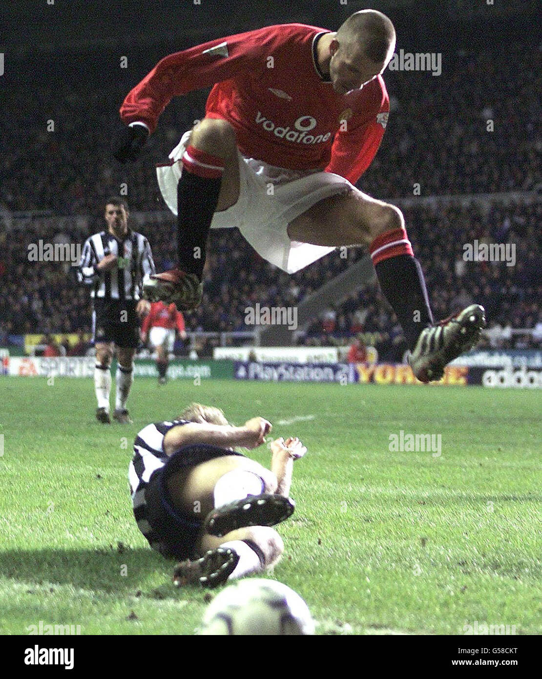 Manchester United's David Beckham (centre) jumps high to clear Newcastle United's Warren Barton during the Premiership football match at St James' Park. Stock Photo