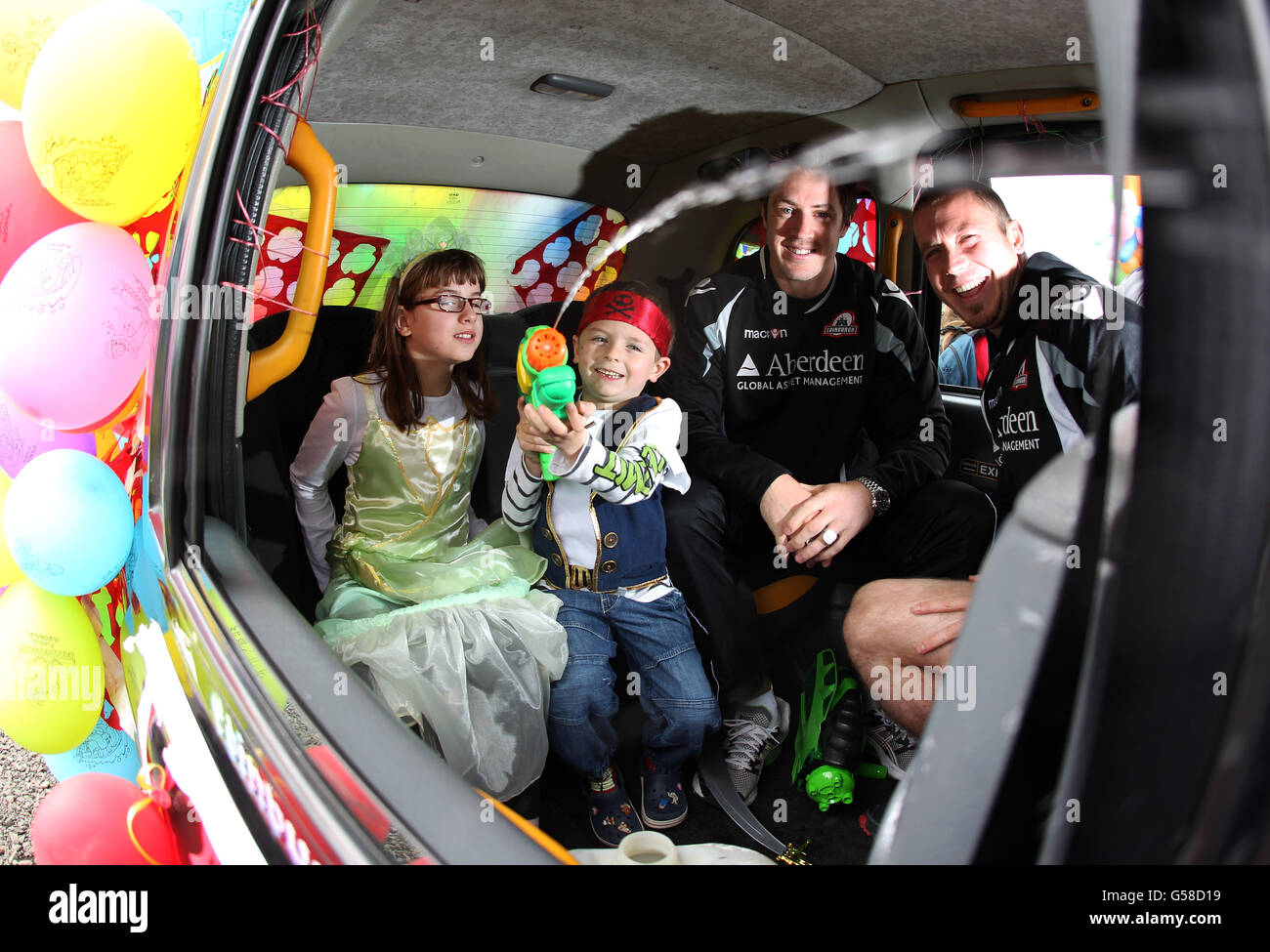 Edinburgh's John Houston and Richie Rees with Emma and Tyler during a photocall at the start of the 66th annual Edinburgh Taxi Trade Children's Outing in Edinburgh. Stock Photo