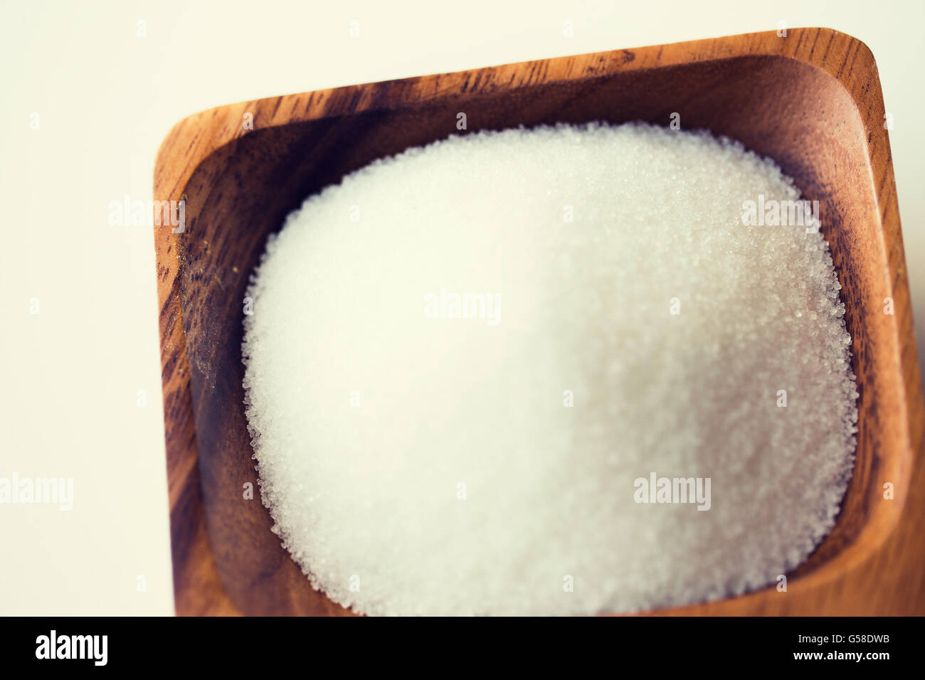 close up of white sugar heap in wooden bowl Stock Photo