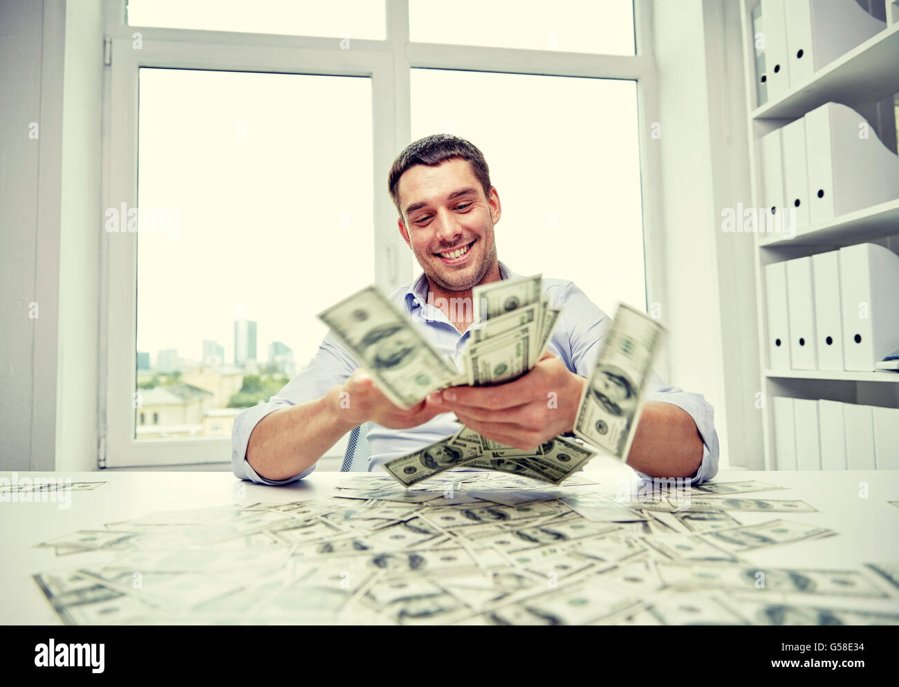 happy businessman with heap of money in office Stock Photo - Alamy