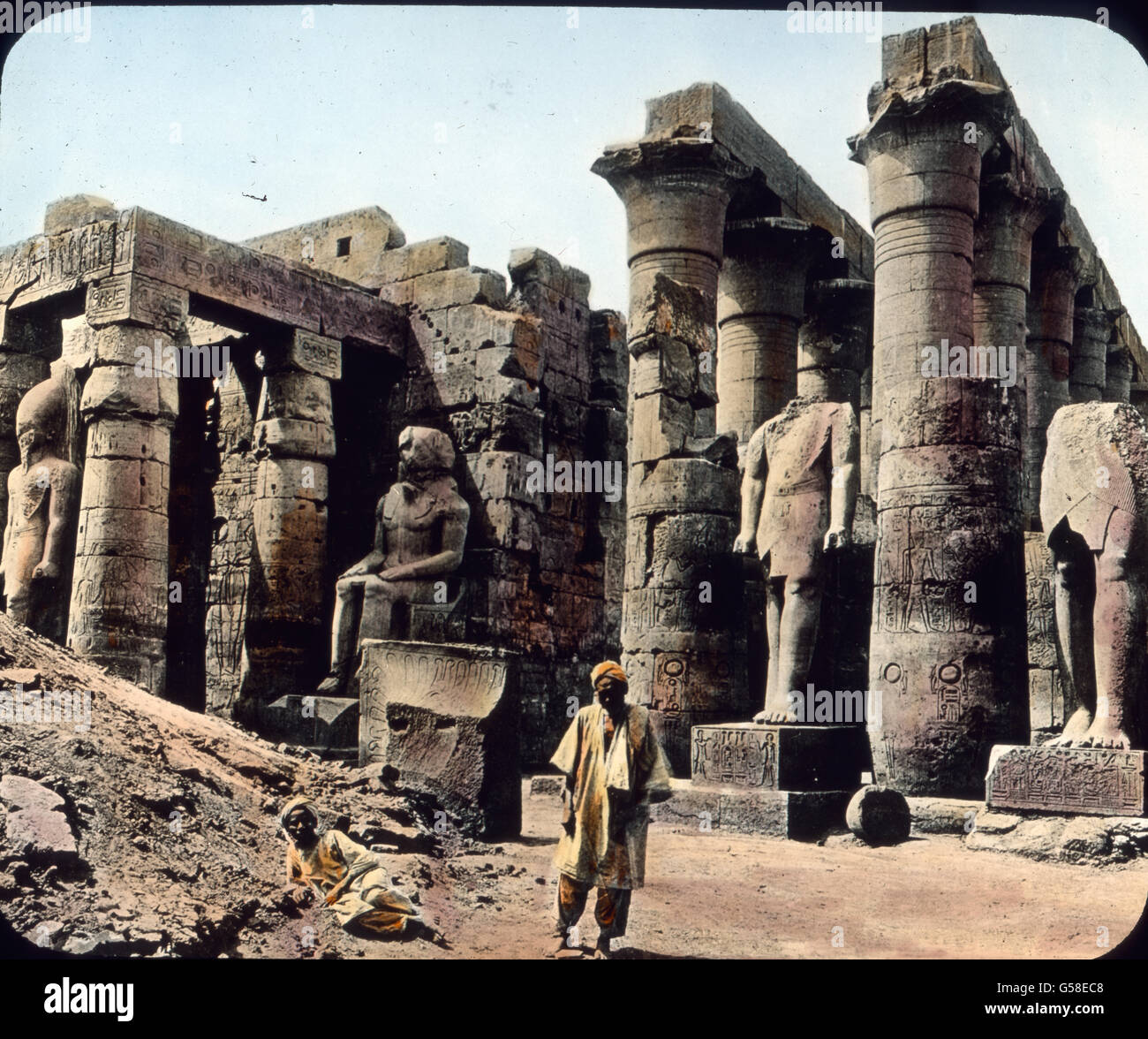 Wir machen jetzt eine Expedition nach Oberägypten. Hier lag in grauer Vorzeit Theben, die alte Hauptstadt des Reiches. Hier erbauten die Herrscher Tempel und Paläste von wahrhaft gewaltiger Größe. Wir sehen hier Ruinen des berühmten Amuntempels, einstmals vielleicht das größte Bauwerk der Welt. Er war 260 m lang und über 100 m breit. Dort stehen noch heute die größten Säulen der Welt. Erbaut wurde der Tempel um 1400 v. Chr. Es sei aber erwähnt, dass dieser Tempel nicht das einzige Denkmal altägyptischer Baukunst ist.  Trip around the world, Egypt, Luxor,Temple of Amun,  travel, journey, 1920s, Stock Photo