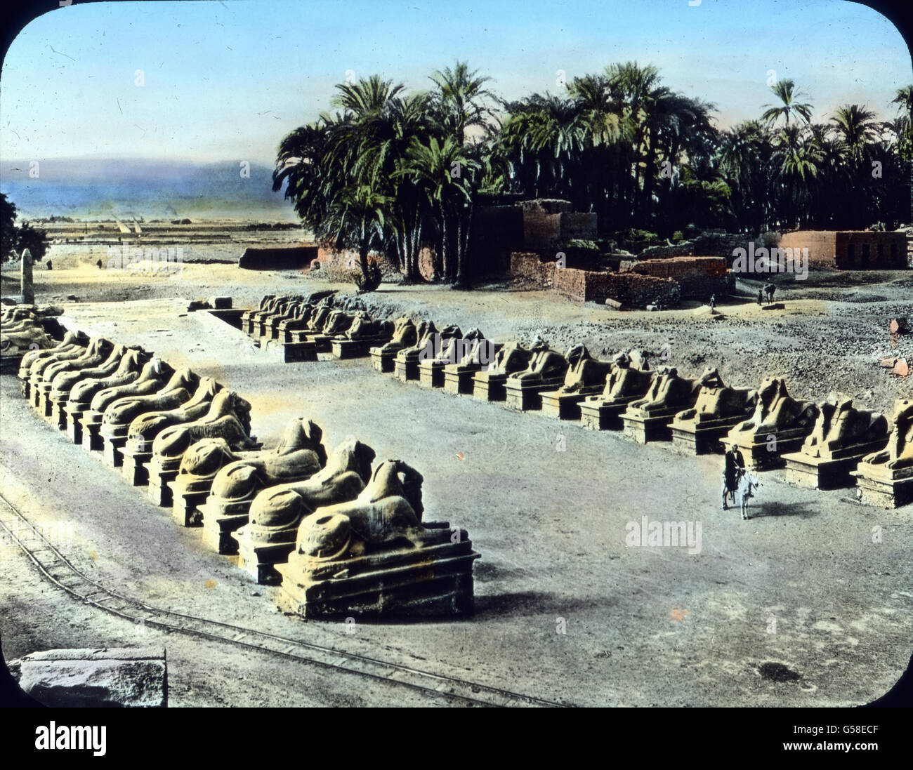 Die Orte Luxor und Karnak, die sich heute auf der Stätte des alten Theben erheben, sind eine einzige gewaltige Ruinenstätte. Gut erhalten hat sich diese einzigartige Sphinxallee, die zu einem Tempel in Karnak hinleitet. Wir haben aber nicht Zeit, in den interessanten Ruinen weiter zu forschen oder gar die Reliefs und Inschriften zu entziffern. Wir müssen auch vom Lande der Pharaonen Abschied nehmen, denn weit ist noch die Reise um die Welt und viel haben wir noch zu sehen. Trip around the world, Upper Egypt, Karnak, Sphinxes alley,  travel, journey, 1920s, 20th century, Archive, Carl Simon, hi Stock Photo