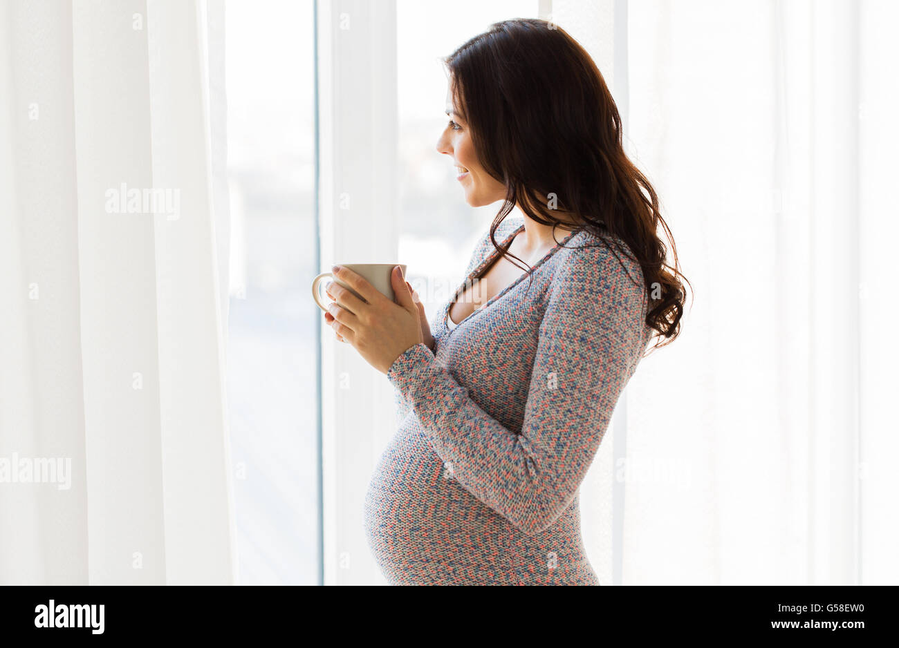 close up of pregnant woman with tea cup at window Stock Photo - Alamy