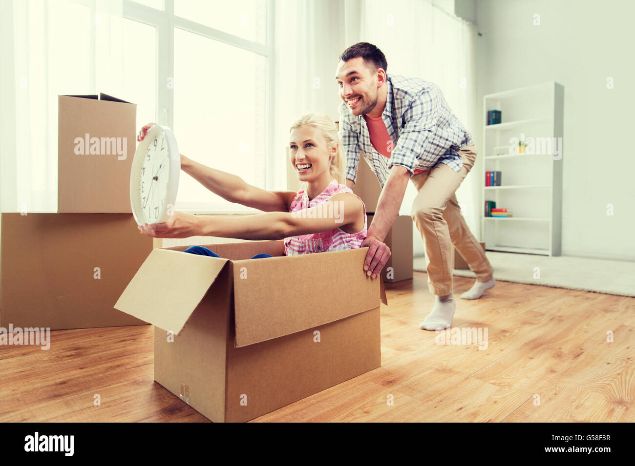 couple with cardboard boxes having fun at new home Stock Photo