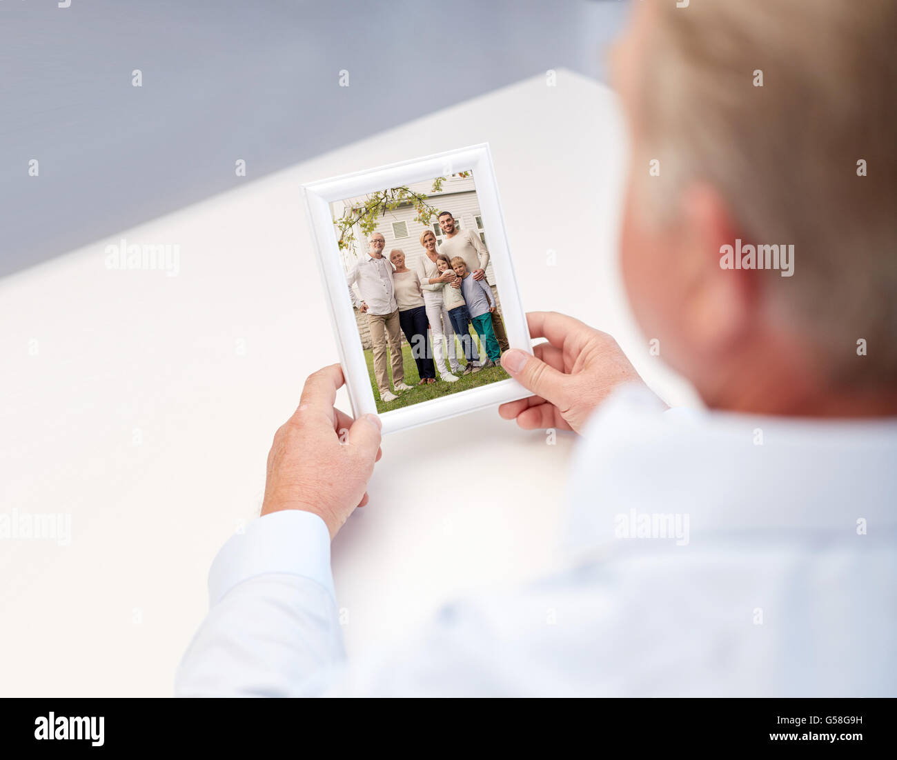 close up of old man holding happy family photo Stock Photo