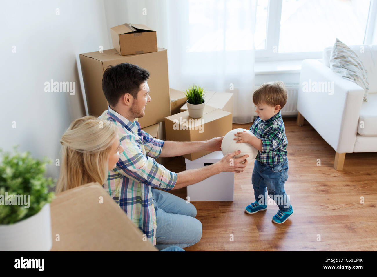 happy family moving to new home and playing ball Stock Photo - Alamy