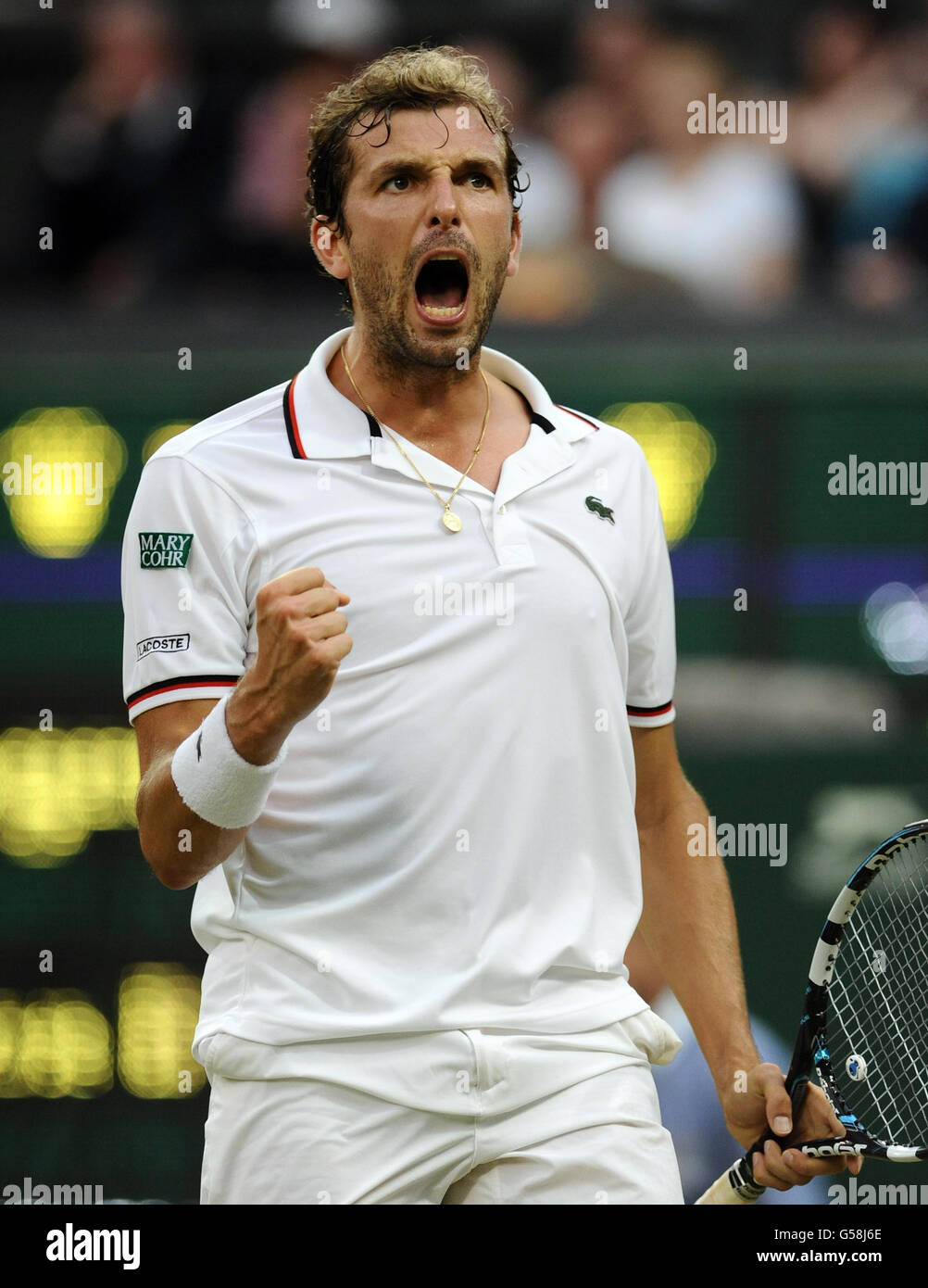 France's Julien Benneteau celebrates winning the second set from  Switzerland's Roger Federer on Centre Court during day five of the 2012  Wimbledon Championships at the All England Lawn Tennis Club, Wimbledon Stock