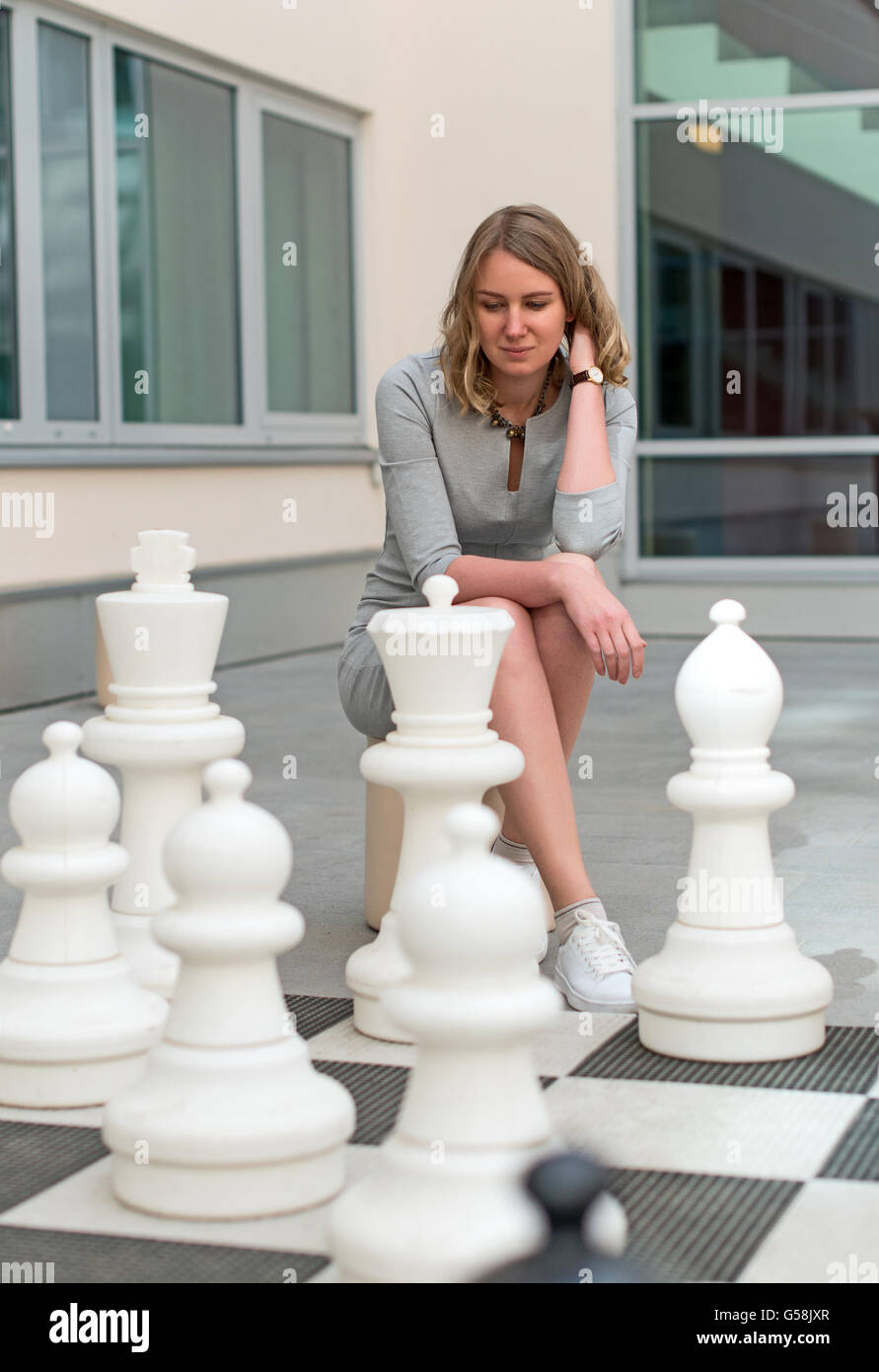 Woman playing outdoor chess game. Stock Photo
