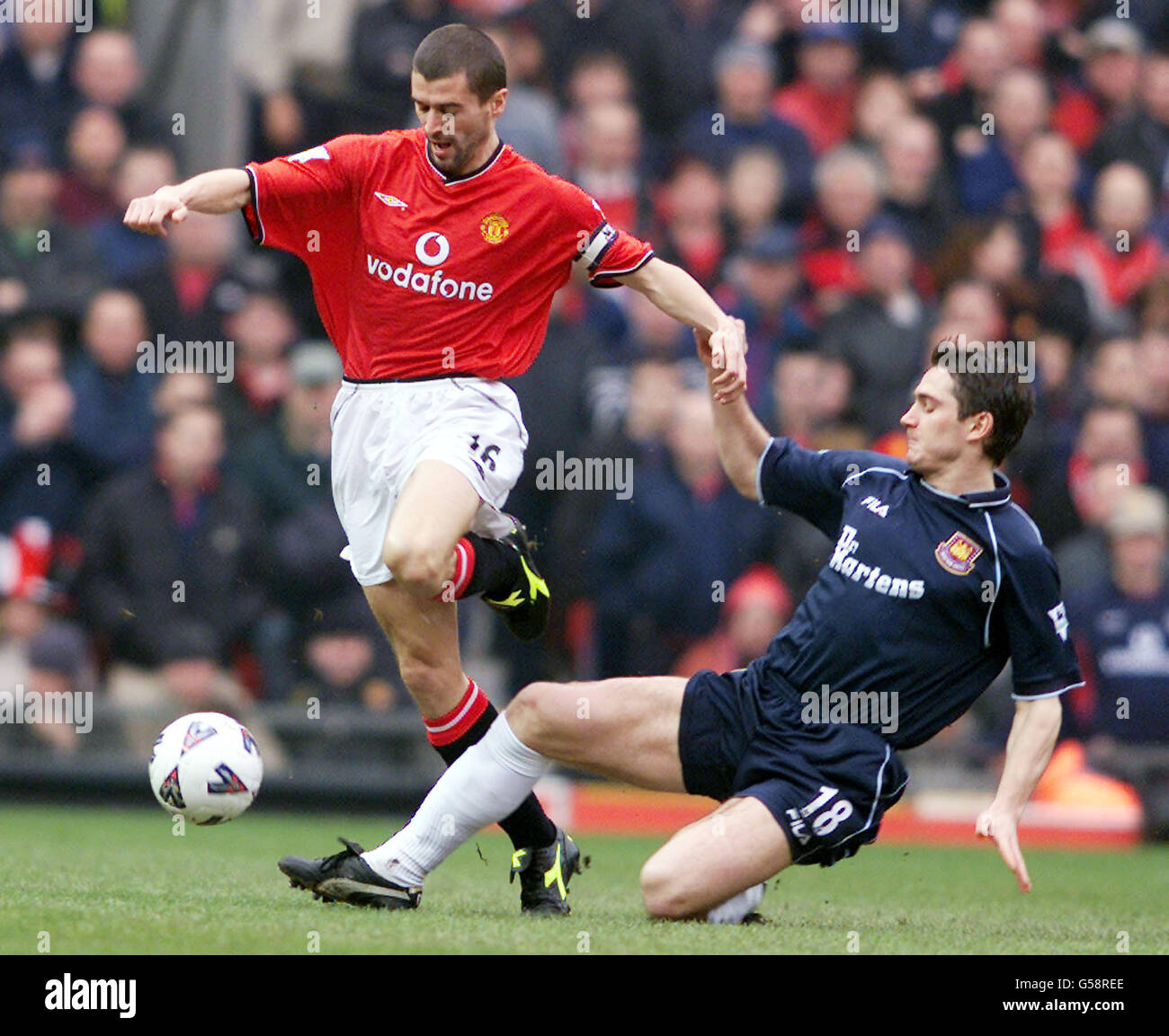 Manchester United's Roy Keane (left) goes round the challenge from West ...