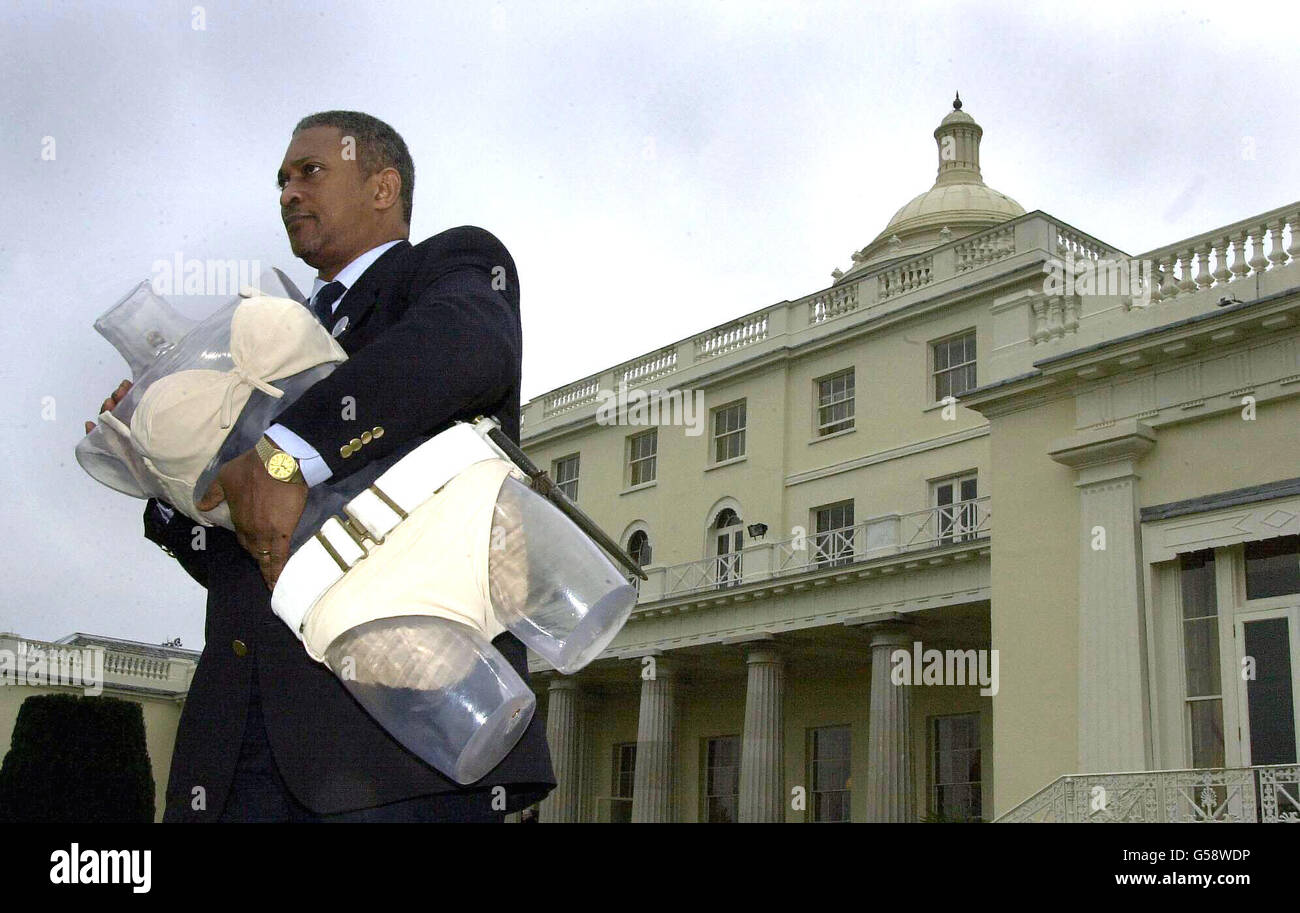 Christie's security officer Geraldo Eghan carries the white bikini worn by Ursula Andress in the 1962 James Bond film Dr No during a Christie's sale preview at Stoke Park Club. The bikini is expected to fetch 40,000 during a sale of Bond memorabilia. Stock Photo