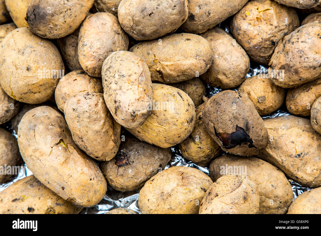 Potatoes, baked in the embers of a campfire, food, burning ash, glow, Stock Photo
