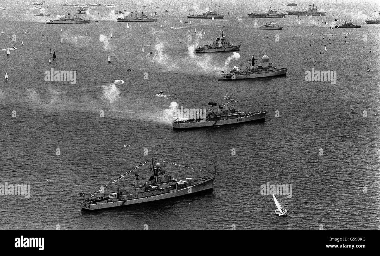 Warships firing a 21-gun salute along the seven mile review line at the Silver Jubilee Review of the fleet which was taken by the Queen aboard the Royal Yacht Britannia at Spithead. Stock Photo
