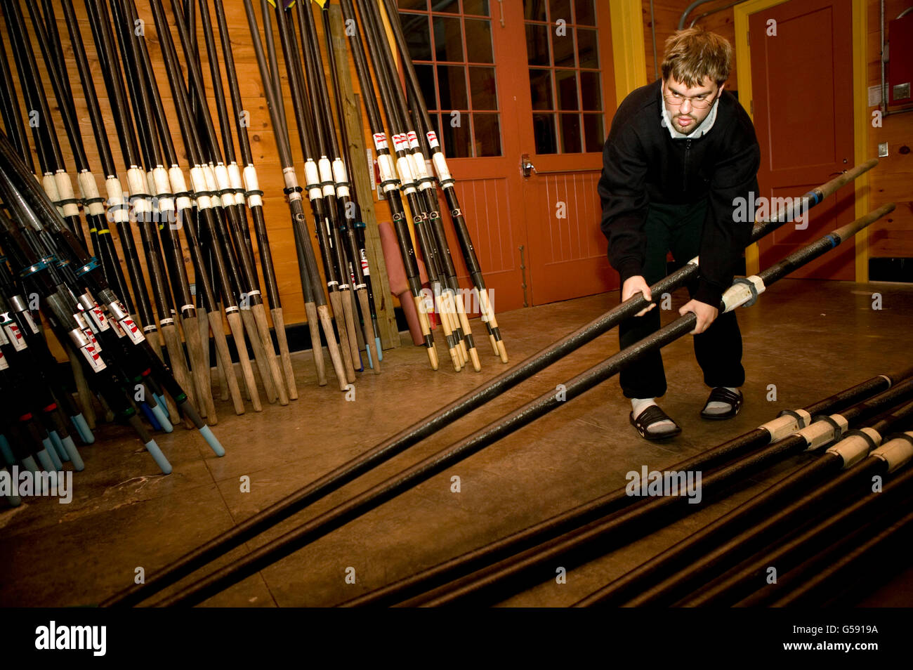 A Manhattan College Rowing Club member prepares oars at the Peter Jay Sharp boathouse, Harlem River, New York, 11 November 2004 Stock Photo