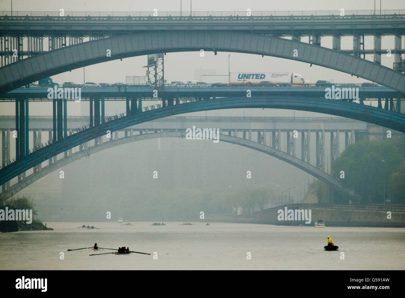 A referee's boat (R) follows two boats racing in the NYRA Scholastic Invitational regatta on the Harlem River in New York City, Stock Photo