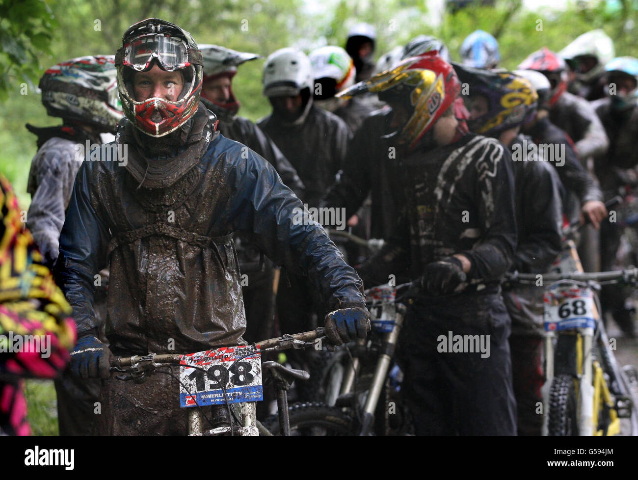 Competing Mountain Bike racers try out the forest trails covered in deep mud at the iXS European Downhill Cup race in Innerleithen, Scotland, ahead of the start of the racing. Stock Photo