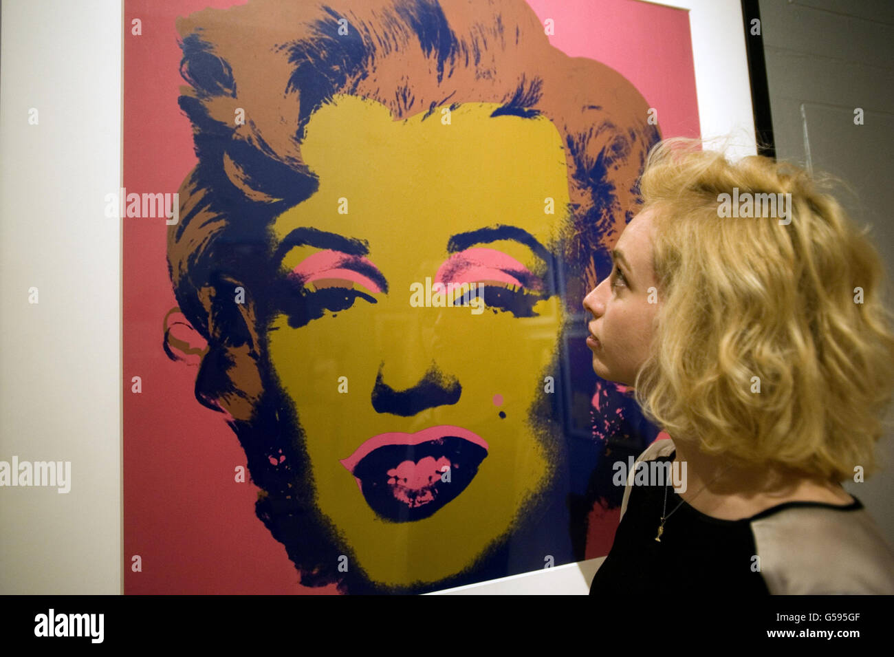 Ellie Manwell views a silk screen print of Marilyn Monroe by Andy Warhol hung at the Dulwich Picture Gallery ahead of a major new exhibition of the US artist's work. Stock Photo