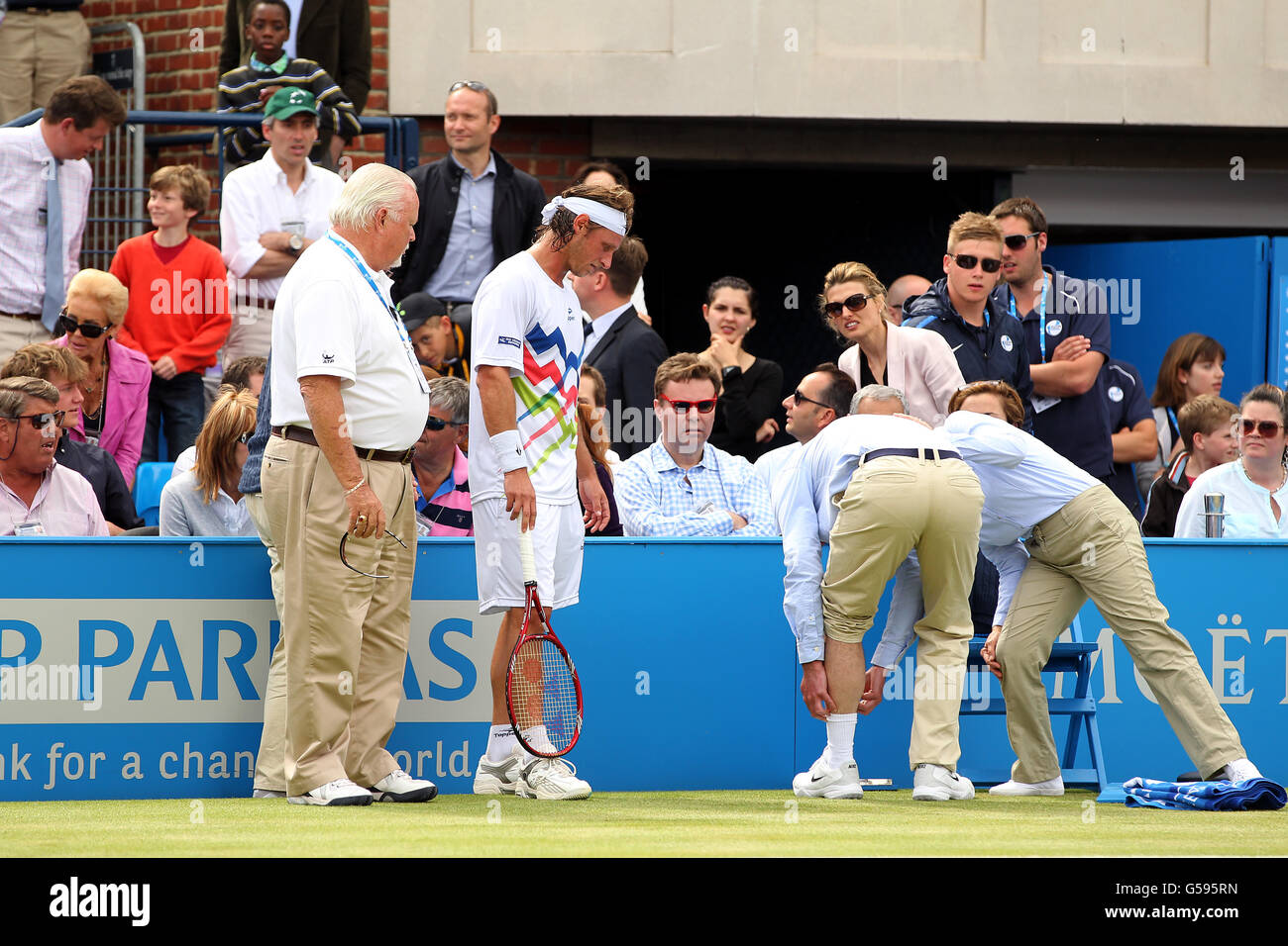Argentina's David Nalbandian (centre left) loses the match by default after an incident involving a line judge (centre right) needing medical treatment for a cut to the leg during the final on day seven of the AEGON Tennis Championships 2012 at The Queen's Club, London Stock Photo