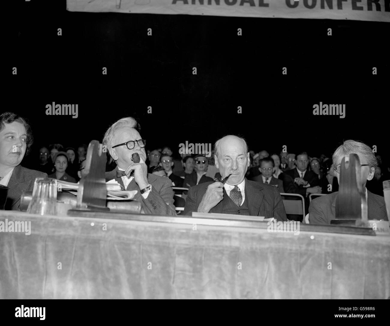 Puffing at their pipes as they listen to speeches, Party Leader Clement Attlee (r) and Herbert Morrison (grandfather of Peter Mandelson) at the 1955 Labour Party Conference, held at Margate. Stock Photo