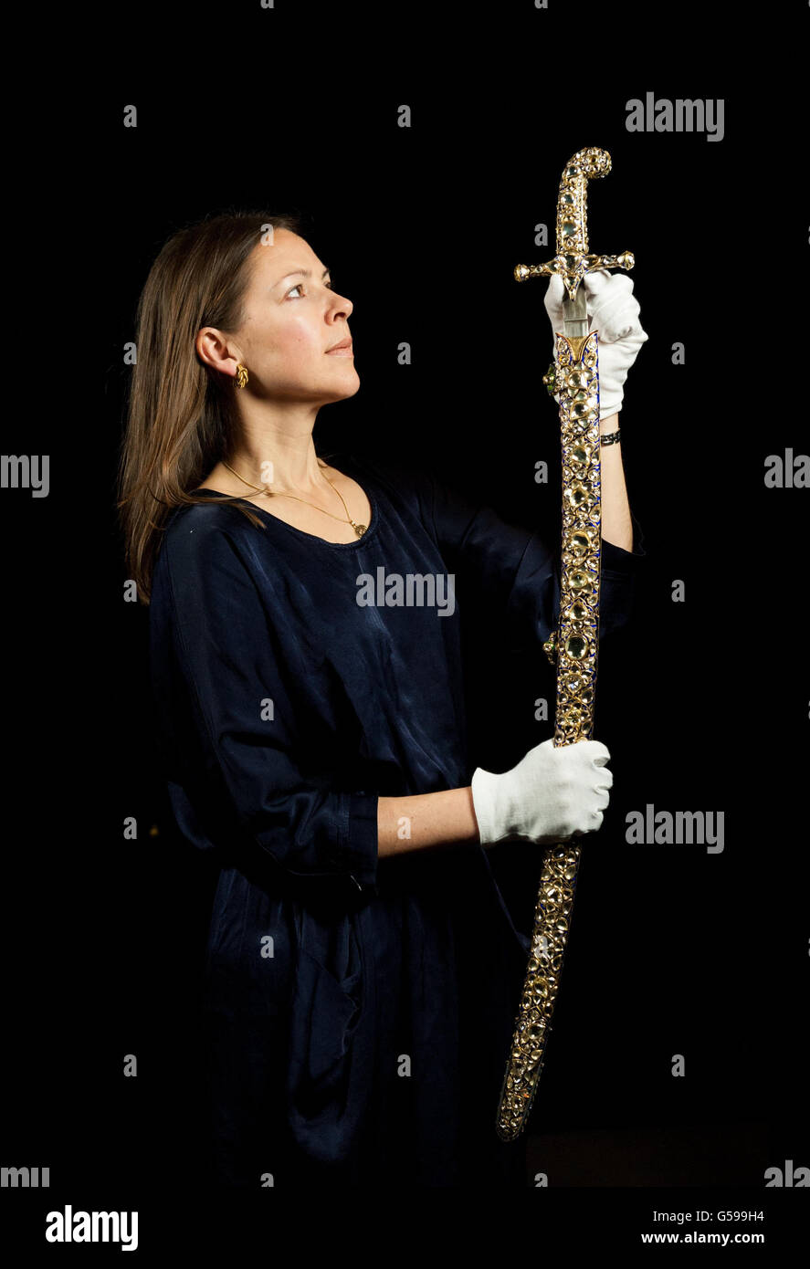 Exhibition Curator Caroline de Guitaut holds a Jaipur Sword and Scabbard, set with 719 diamonds weighing a total of 2,000 carats, originally presented to King Edward VII for his coronation in 1902 by the Maharajah of Jaipur, part of the 'Diamonds: A Jubilee Celebration' exhibition, at Buckingham Palace, in central London, from 30 June to 8 July 2012, and 31 July to 7 October 2012. Stock Photo