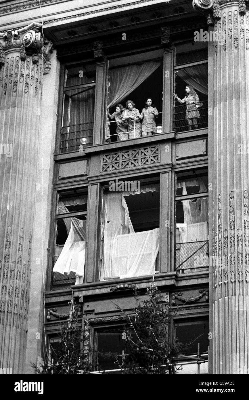 Employees of Selfridge's look out at the depressing scene from the windows of the damaged store. Curtains hang untidily at the smashed windows, in bizarre contrast to the tops of the Christmas trees. Stock Photo