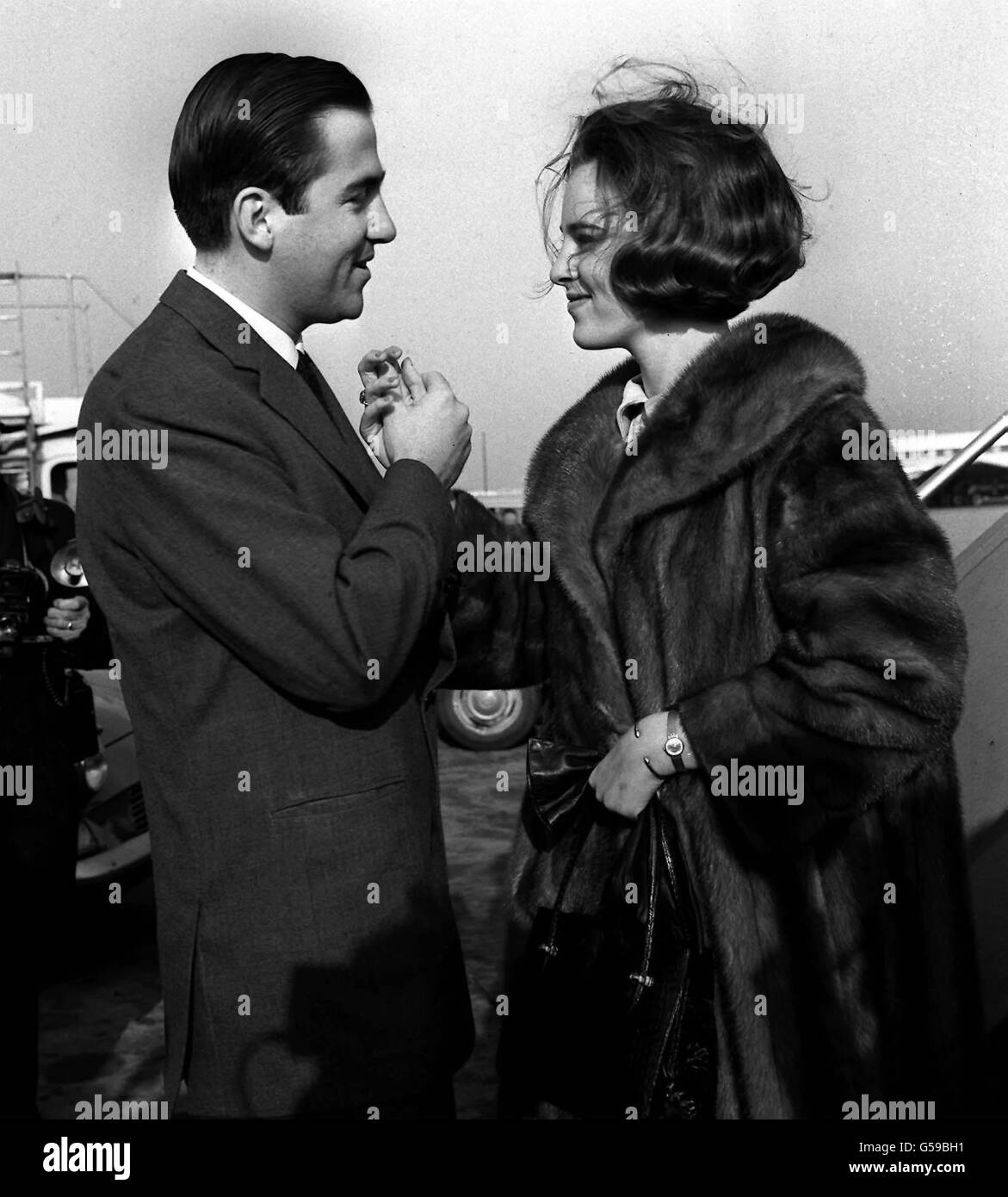1965: A clasp of the hands as King Constantine of Greece greets his young wife, Queen Anne-Marie, on her arrival at London Airport from Copenhagen. The Queen will stay privately in Britain for a few days before returning to Greece with her husband. Stock Photo