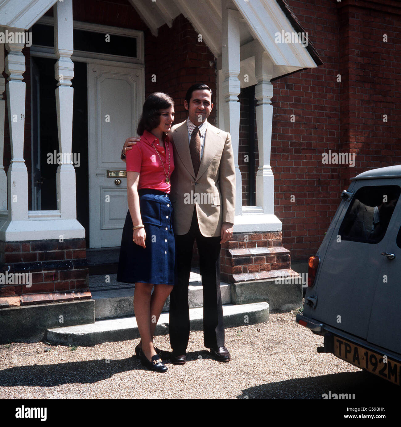 1974: The exiled King Constantine of Greece and his wife, Queen Anne-Marie, stand in front of their Victorian home in Chobham, Surrey, England, where a Mini estate car is also waiting. Stock Photo