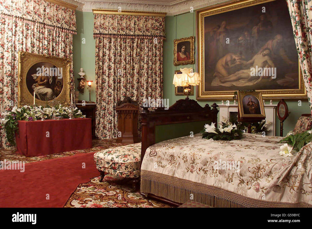 Queen Victoria's bedroom at Osborne House, her home on the Isle of Wight. The room has been recreated as it was after her death there on 22/01/1901, as part of an extensive refurbishment of Osborne House to commemorate a century since her death. * Victoria was Britain's longest reinging monarch. The bed is decorated with lillies and palms. An alter is set up on the opposite side of the room in the same way as done so by her children to mourn her with effigies of both Victoria and Albert. Most of the items are from the Royal Collection. Stock Photo