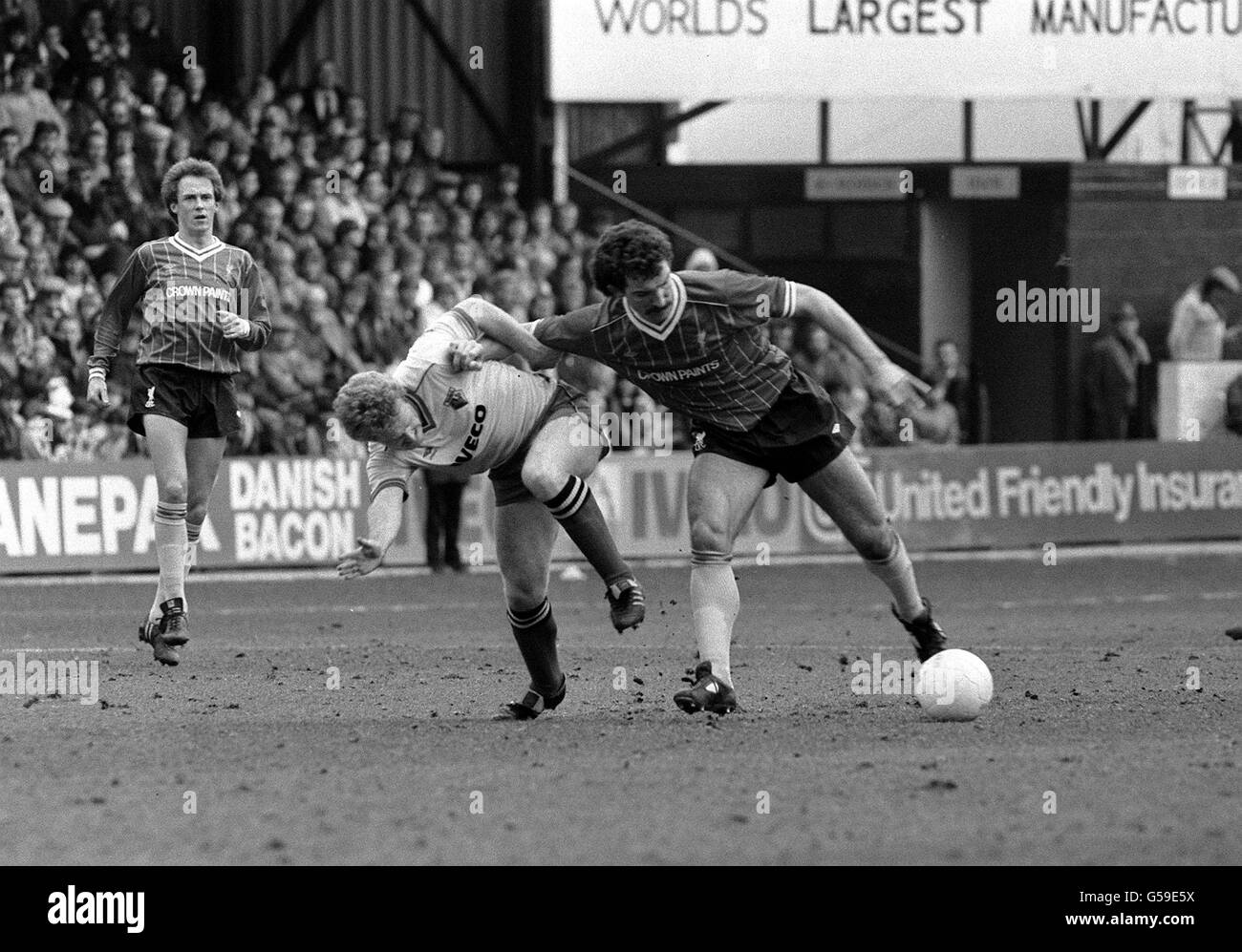 Watford 's Les Taylor (centre left) and Liverpool captain Graeme Souness (right) battle for the ball, during their Division One football match at Vicarage Road, in London. Stock Photo