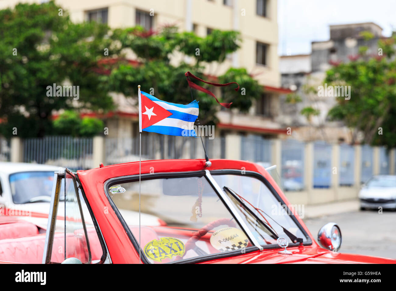 Cuban flag on a red opentop classic car taxi in Havana, Cuba Stock