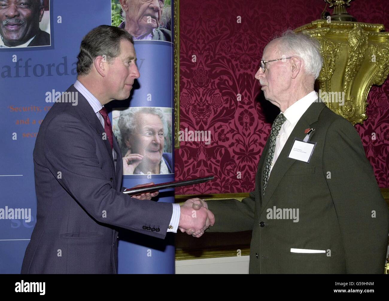 Prince of Wales shakes hands with Eric Broughton from Surrey, as he is presented with an award for his volunteer work for the Abbeyfield Society. The Prince, Patron of the Abbeyfield Society was at St James's Palace in London. *.. to salute some of the 15,000 workers of the Society, who help to alleviate isolation for the elderly, and provide care at sheltered accomodation around Britain. Stock Photo