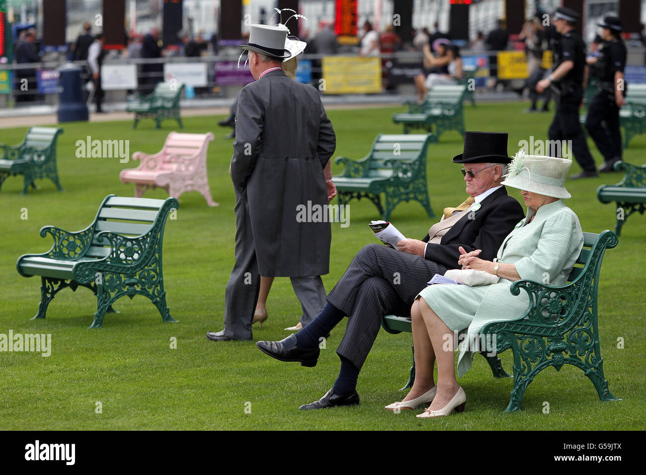 Racegoers read the racing programme during day two of the 2012 Royal Ascot meeting. Stock Photo