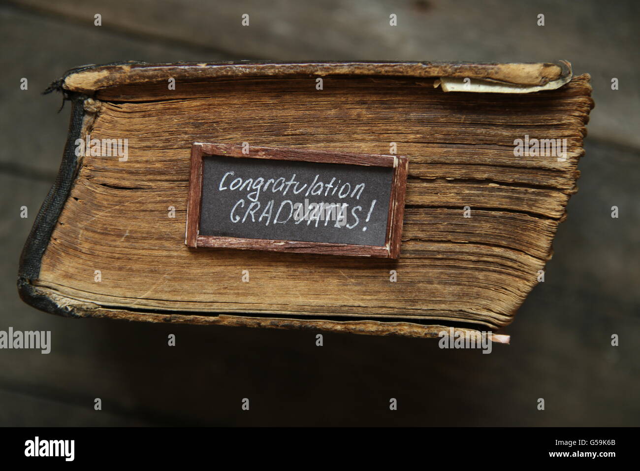 congratulations graduates text and vintage book on table Stock Photo