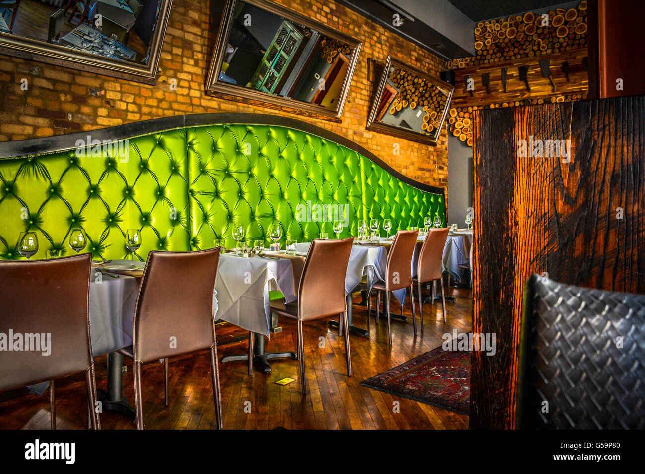 The posh lime green upholstered booths with brick-lined walls in Interior of the Cork & Cow Restaurant in historic Franklin, TN Stock Photo