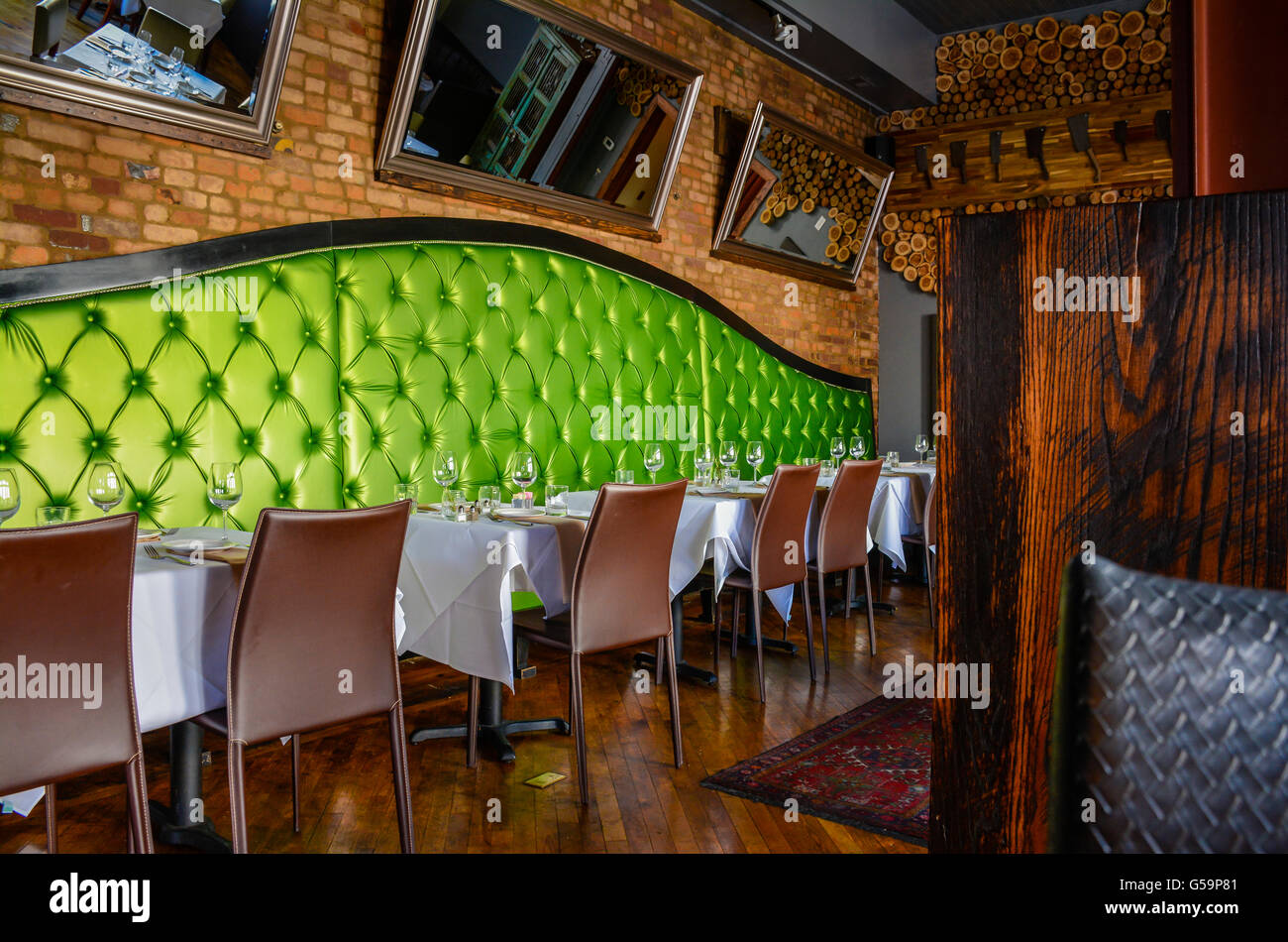 The posh lime green upholstered booths with brick-lined walls in Interior of the Cork & Cow Restaurant in historic Franklin, TN Stock Photo