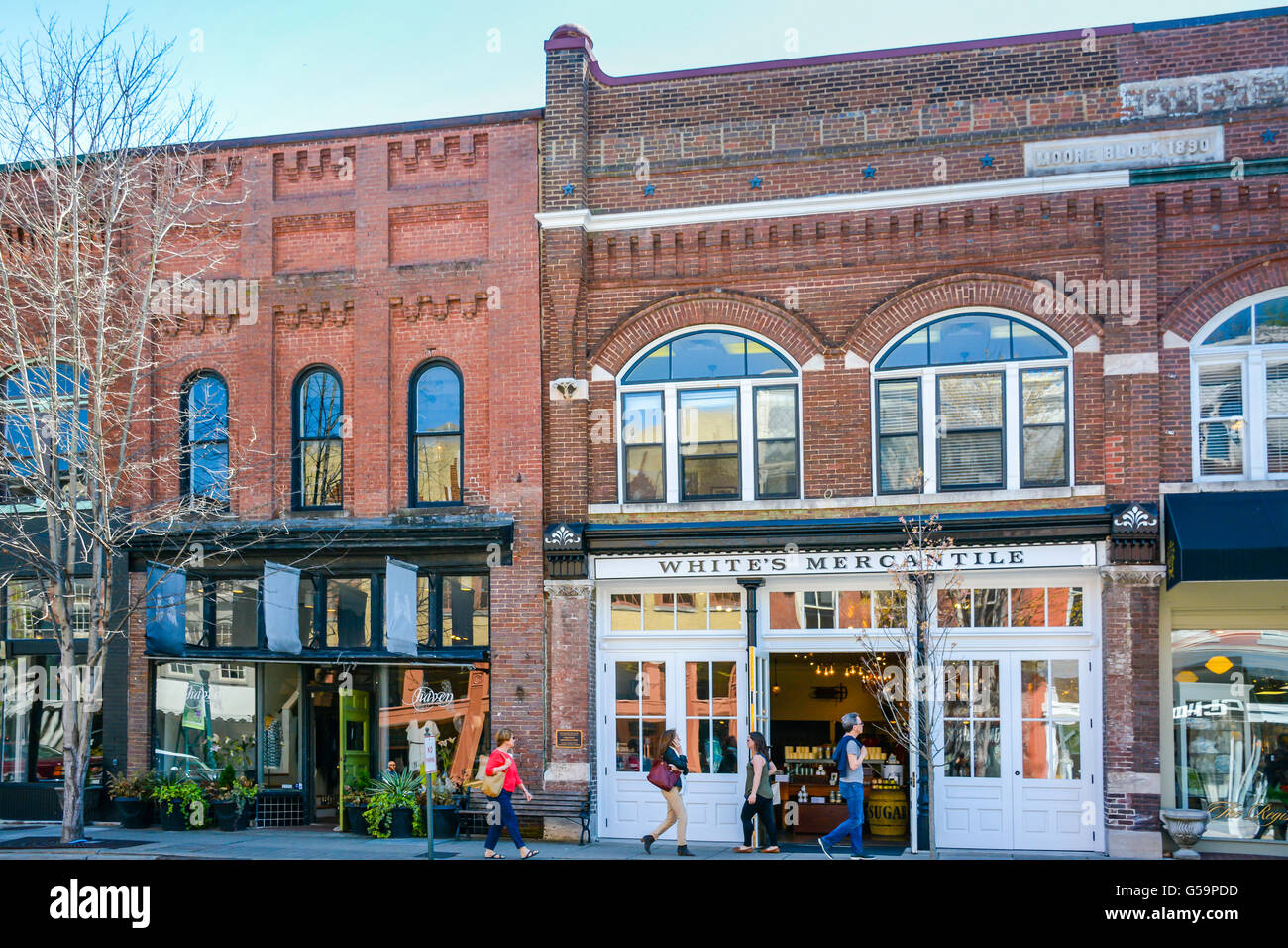 People strolling on sidewalk in front of White's Mercantile store on